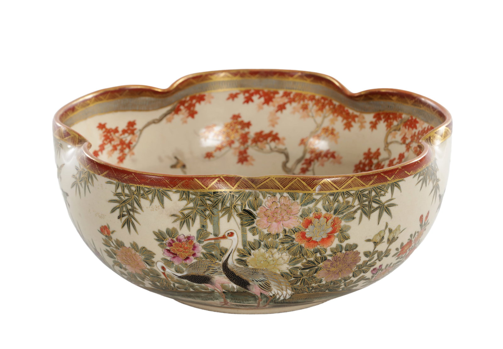 A JAPANESE MEIJI PERIOD SATSUMA EARTHENWARE BOWL: A JAPANESE MEIJI PERIOD SATSUMA EARTHENWARE BOWL of lobed circular form with a scalloped rim, finely decorated with panels of cranes, ducks and other birds amongst flowering plants and bamboo in a riv