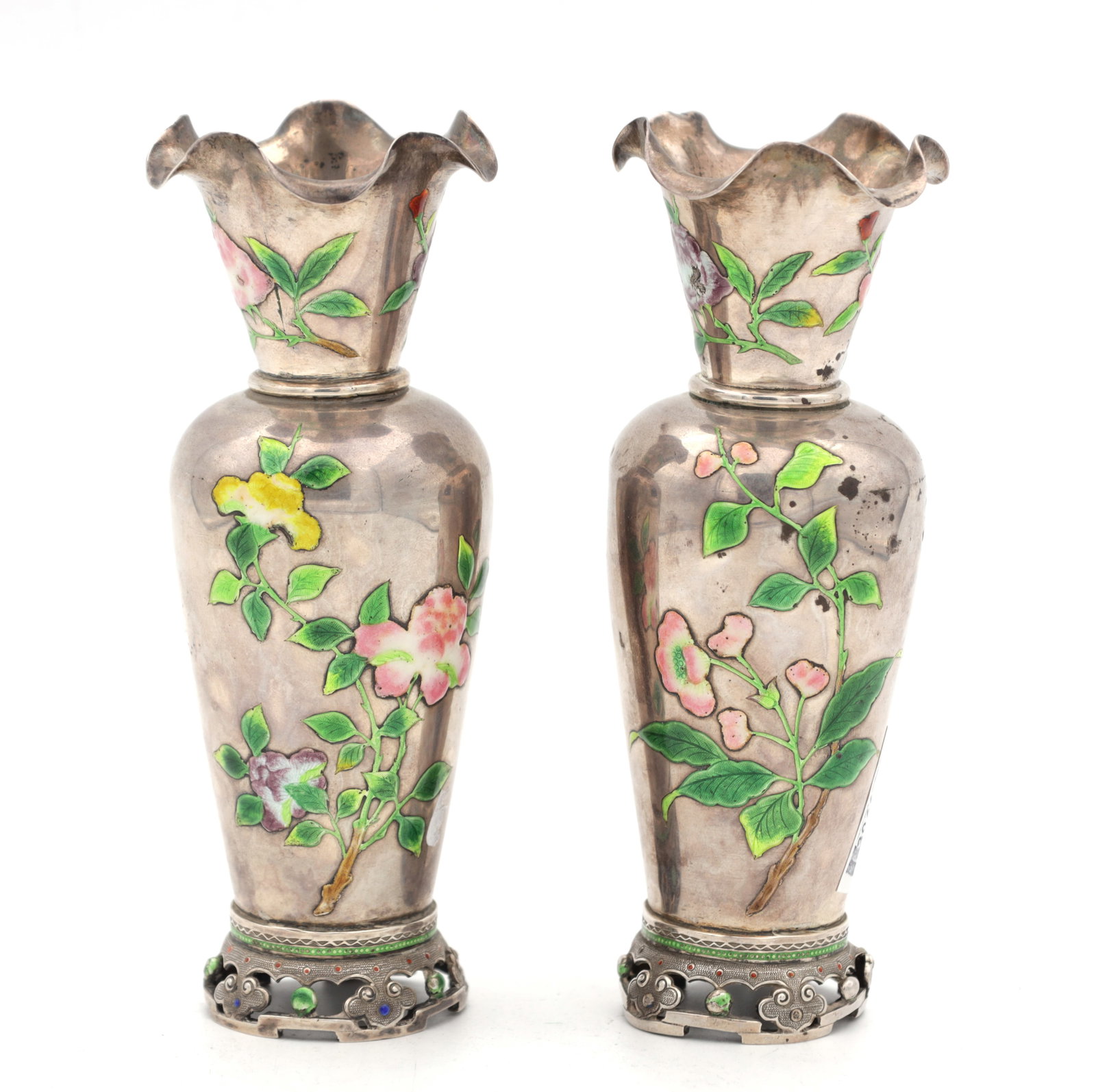A PAIR OF CHINESE ENAMELLED SILVER VASES: A PAIR OF CHINESE ENAMELLED SILVER VASES of tapering baluster form with flared crimped rims, enamelled with polychrome floral sprays, the bases with pierced scroll mounts set with cabochon beads. (13.