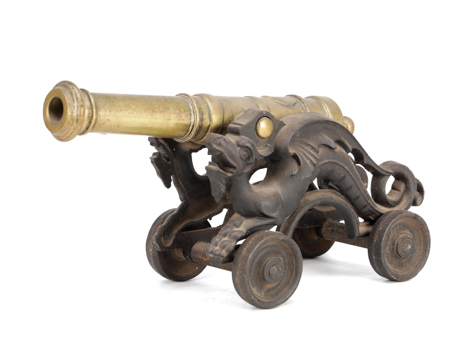 A 19TH CENTURY BRASS MODEL OF A SIGNAL CANNON ON CAST IRON DRAGON CARRIAGE: A 19TH CENTURY BRASS MODEL OF A SIGNAL CANNON ON CAST IRON DRAGON CARRIAGE of ring-turned barrel with moulded muzzle and cascabel, the four-wheeled carriage cast with opposed dragons and scrolling sup
