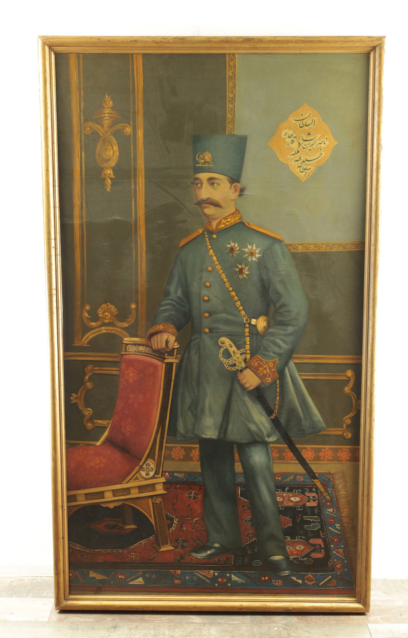 A FULL-LENGTH PORTRAIT OF NASIR AL-DIN SHAH QAJAR OIL ON CANVAS: A FULL-LENGTH PORTRAIT OF NASIR AL-DIN SHAH QAJAR OIL ON CANVAS who was the Shah of Persia (Iran) from 1848 to 1896, he is wearing a European-style military frock coat with gold epaulettes and a cerem