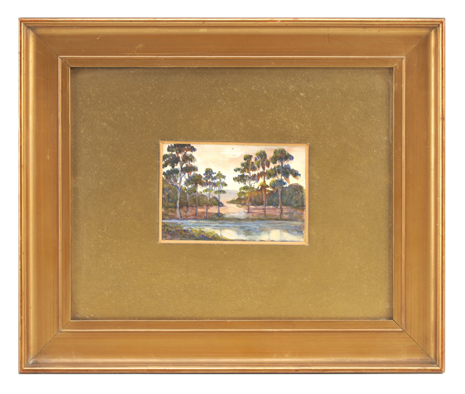 A 20TH CENTURY WATERCOLOUR ON PAPER LANDSCAPE WITH SCOTS PINES: A 20TH CENTURY WATERCOLOUR ON PAPER LANDSCAPE WITH SCOTS PINES depicting tall pines beside a stretch of water with distant hills, mounted within a gilt frame. (7.5cm high, 11cm wide)