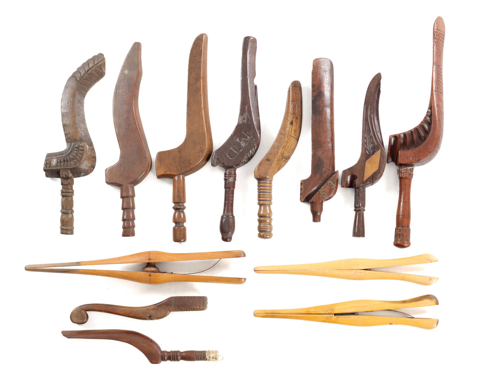 A COLLECTION OF 19TH AND EARLY 20TH CENTURY CARVED WOOD TREEN KNITTING SHEATHS INCLUDING GLOVE: A COLLECTION OF 19TH AND EARLY 20TH CENTURY CARVED WOOD TREEN KNITTING SHEATHS INCLUDING GLOVE STRETCHERS comprising various carved wooden implements with curved and stylised handles, several with geo