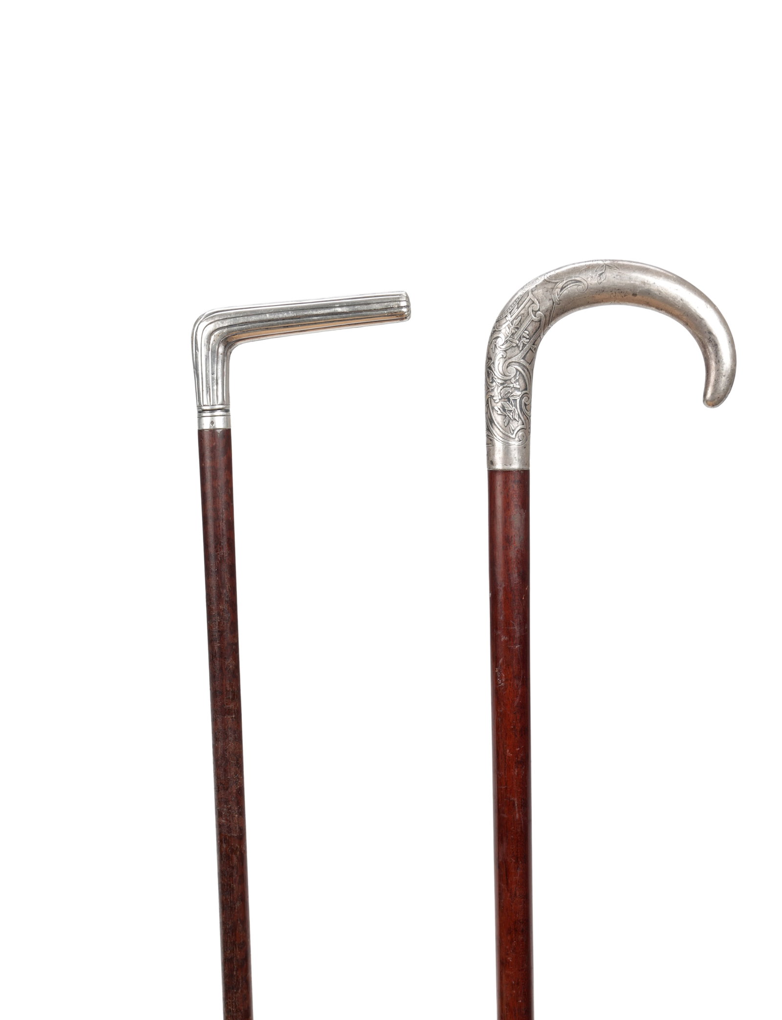 TWO 19TH CENTURY FRENCH SILVER HANDLED WALKING STICKS: TWO 19TH CENTURY FRENCH SILVER HANDLED WALKING STICKS comprising one with a chased crook handle and one with a reeded cranked handle, each with a mahogany shaft. (90cm and 88cm overall)