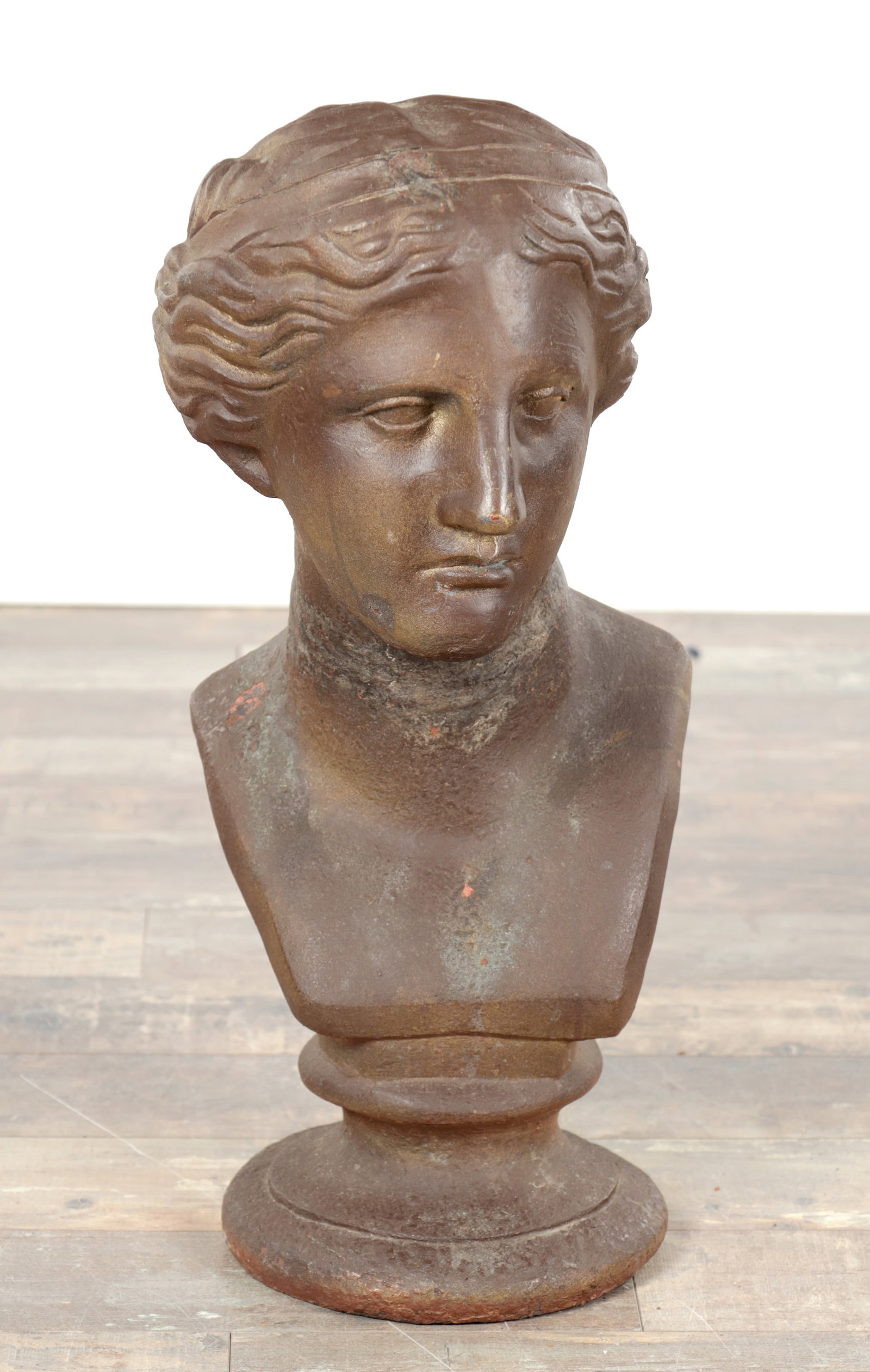 AN EARLY 20TH CENTURY CAST IRON BUST OF NIOBE: AN EARLY 20TH CENTURY CAST IRON BUST OF NIOBE modelled with classical features and bound hair on an integral circular socle. (63cm high)