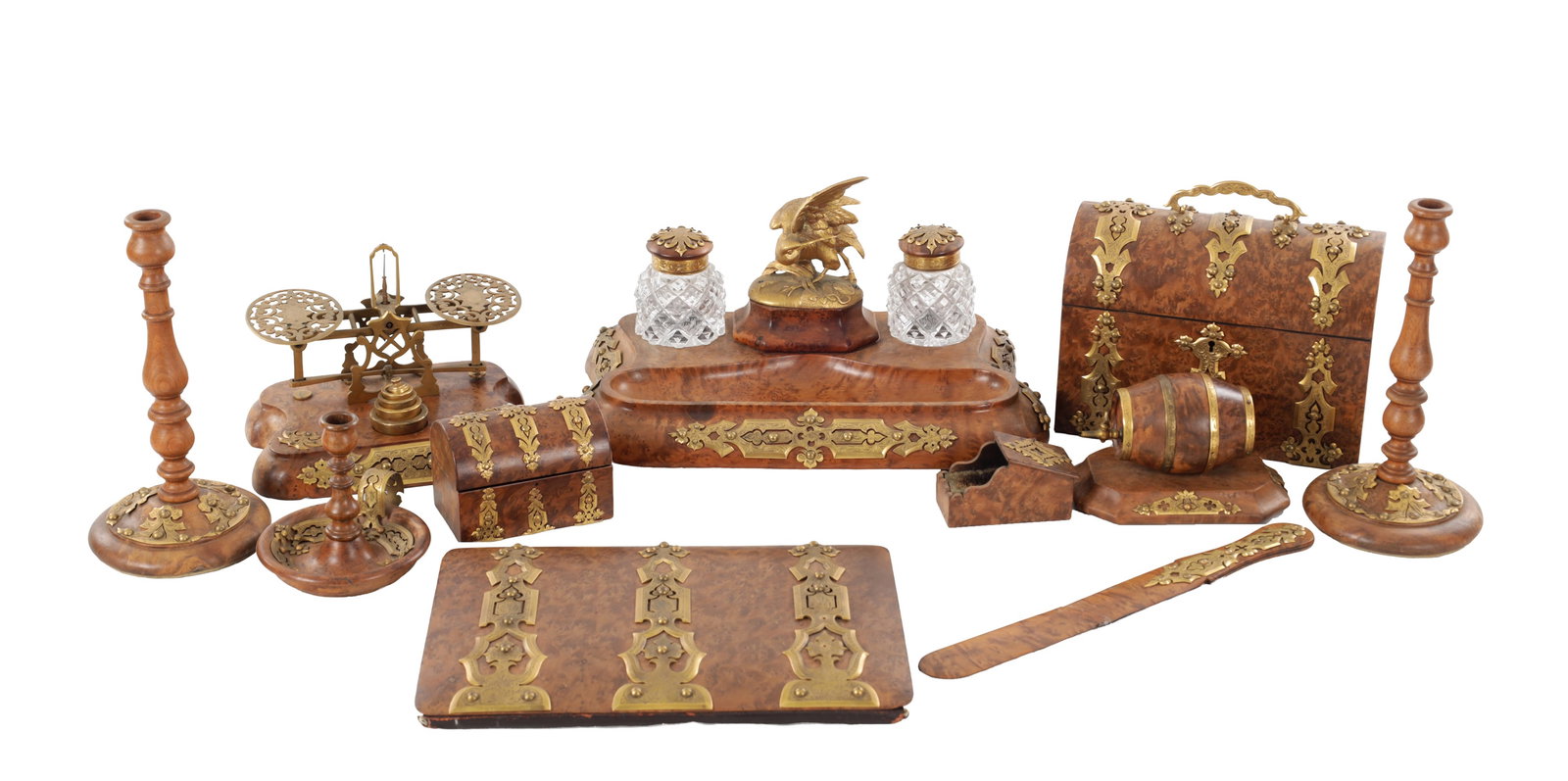 AN ELEVEN-PIECE WILLIAM IV BURR-WALNUT AND GILT-MOUNTED DESK SET: AN ELEVEN-PIECE WILLIAM IV BURR-WALNUT AND GILT-MOUNTED DESK SET circa 1830 comprising a pair of candlesticks, a chamberstick, string container, inkstand with twin cut-glass inkwells and bird finial,