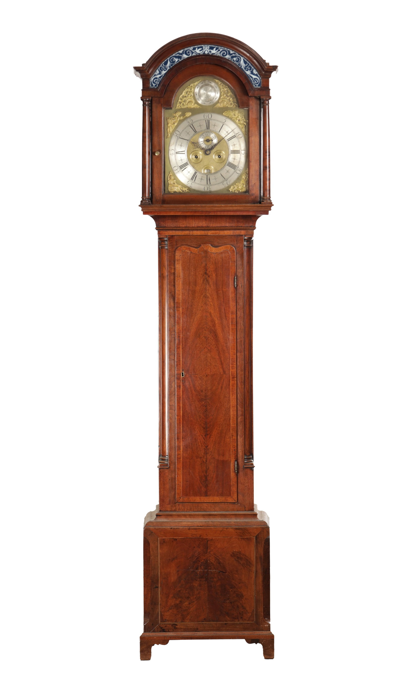 LASSEL, PARK. A GEORGE II FIGURED WALNUT LONGCASE CLOCK: LASSEL, PARK. A GEORGE II FIGURED WALNUT LONGCASE CLOCK having an arched hood with eglomise frieze above a slender trunk with a shaped crossbanded door and canted base, the 12 inch arched brass dial w
