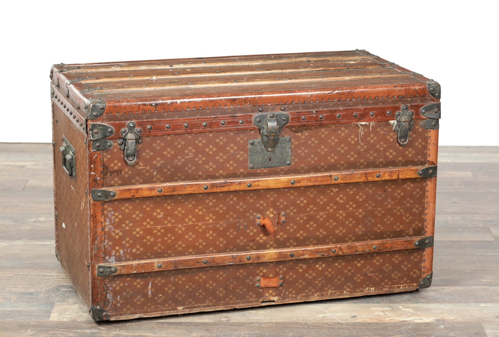 A 19TH CENTURY FRENCH PRINTED LEATHER TRAVELLING TRUNK WITH WOOD SLATS AND IRON MOUNTS: A 19TH CENTURY FRENCH PRINTED LEATHER TRAVELLING TRUNK WITH WOOD SLATS AND IRON MOUNTS the rectangular case with studded borders, battened top and corner protectors, central lock plate and twin front