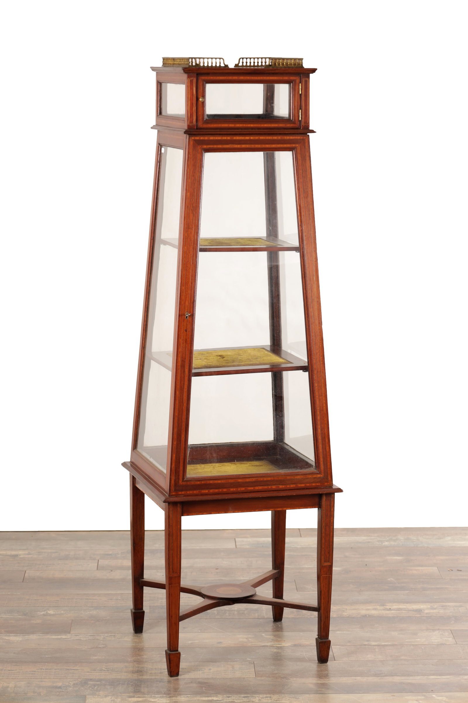 AN EDWARDIAN MAHOGANY TAPERING VITRINE ON STAND WITH BRASS GALLERY: AN EDWARDIAN MAHOGANY TAPERING VITRINE ON STAND WITH BRASS GALLERY of four-sided glazed form with a hinged front door and three internal shelves, the top with a small glazed superstructure and pierced