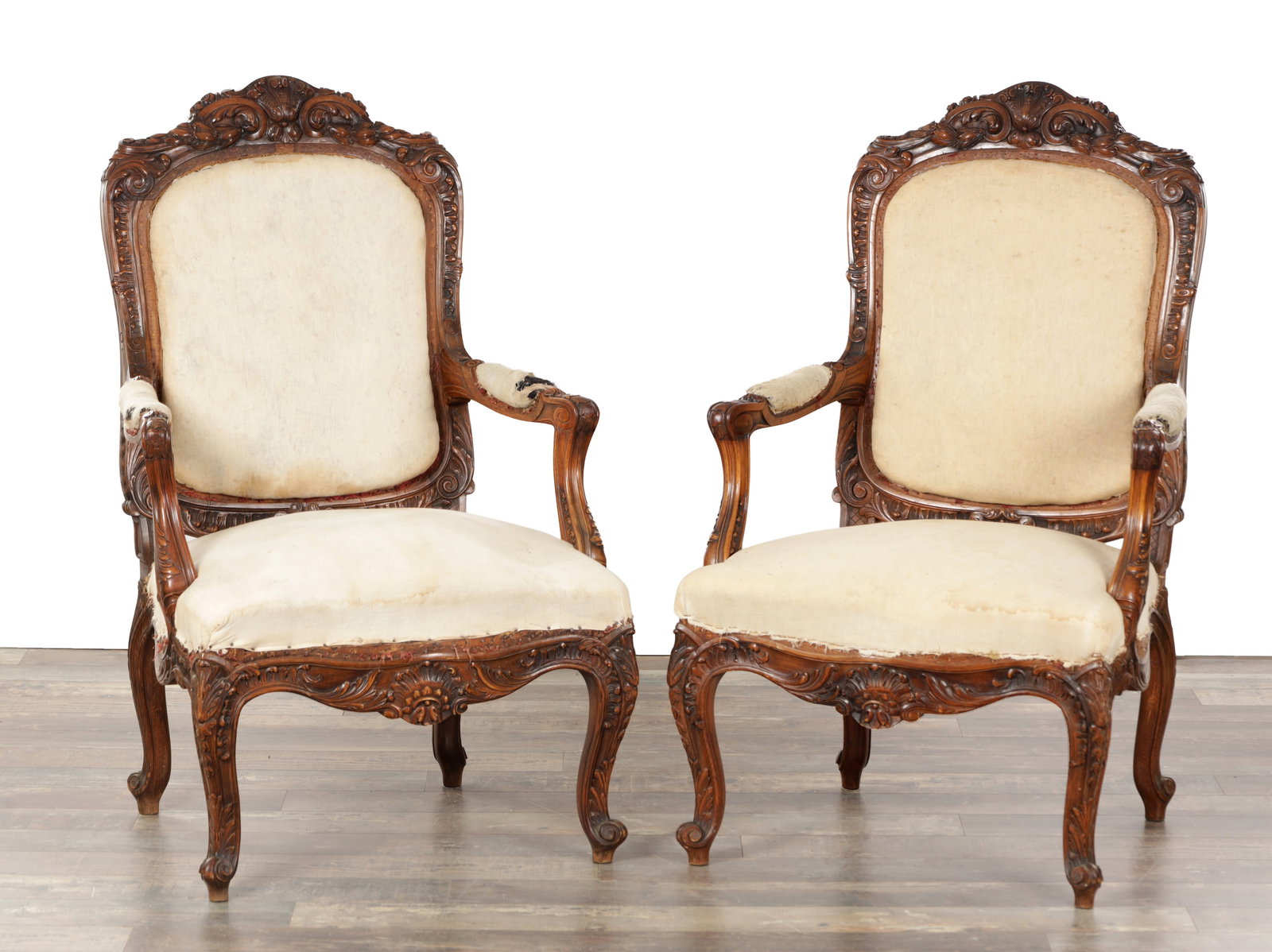 A PAIR OF 19TH CENTURY STYLE UPHOLSTERED CARVED WALNUT OPEN ARMCHAIRS: A PAIR OF 19TH CENTURY STYLE UPHOLSTERED CARVED WALNUT OPEN ARMCHAIRS with padded cartouche backs within rocaille and foliate carved frames, shaped scroll arms on supports, serpentine seats and moulde