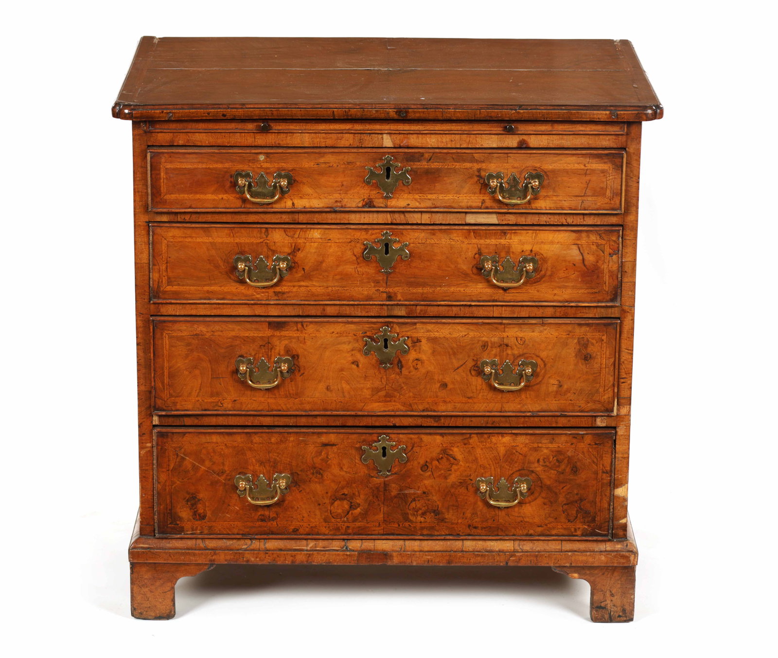A GEORGE I HERRING-BANDED AND FIGURED WALNUT DRESSING CHEST: A GEORGE I HERRING-BANDED AND FIGURED WALNUT DRESSING CHEST the quarter veneered top above a brushing slide and four long graduated drawers fitted with brass handles and shaped escutcheons; raised on