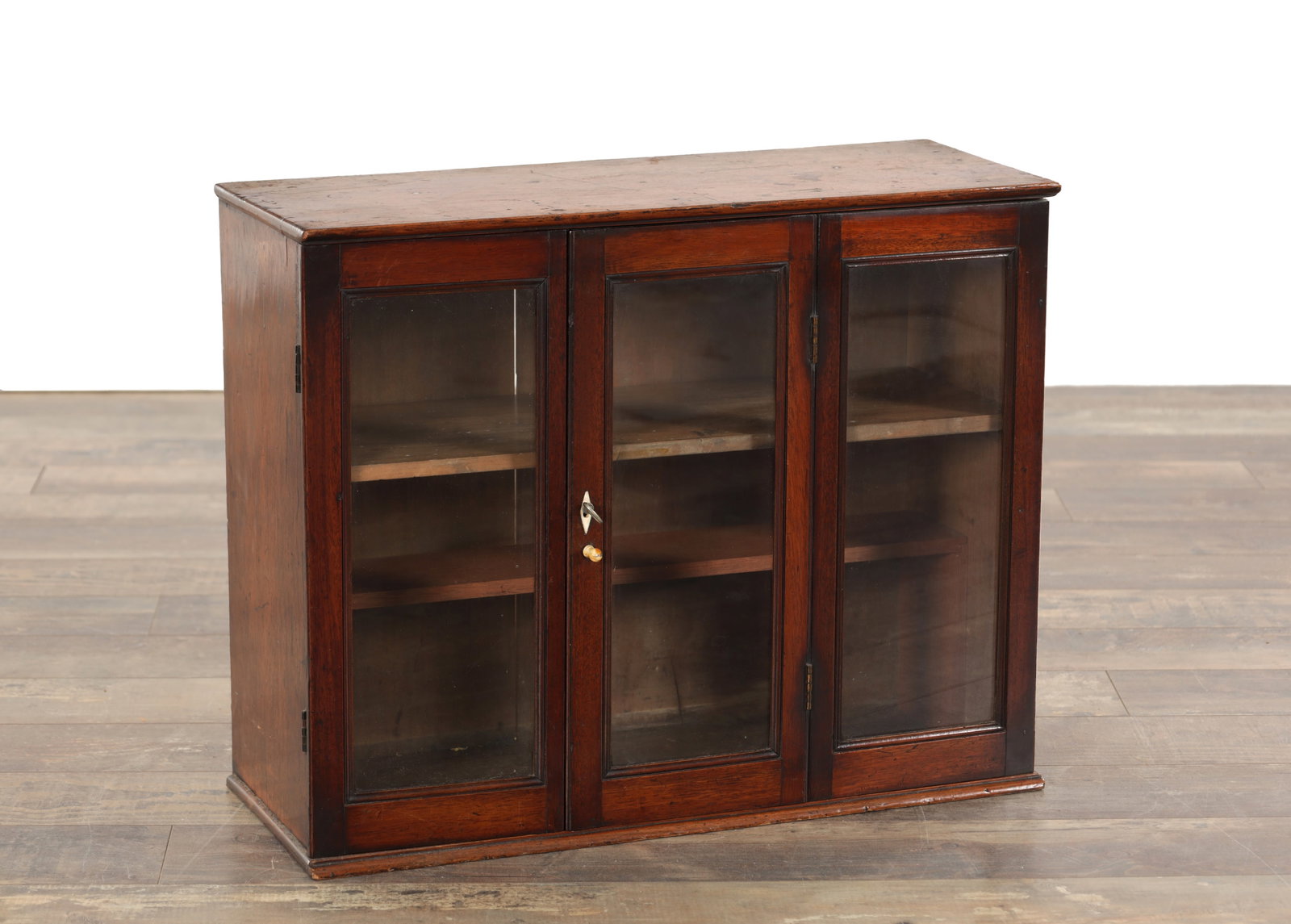 A GEORGE III MAHOGANY GLAZED HANGING CUPBOARD: A GEORGE III MAHOGANY GLAZED HANGING CUPBOARD with hinged triple door and shelved interior. (61cm wide, 24cm deep and 49cm high)
