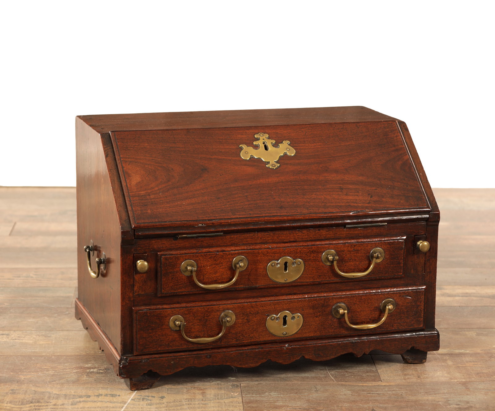 AN 18TH CENTURY ANGLO-CHINESE HARDWOOD DESK TOP BUREAU POSSIBLY HUANGHUALI WITH BRASS MOUNTS: AN 18TH CENTURY ANGLO-CHINESE HARDWOOD DESK TOP BUREAU POSSIBLY HUANGHUALI WITH BRASS MOUNTS having a sloping fall with shaped escutcheon revealing a stepped interior of small drawers above two long d
