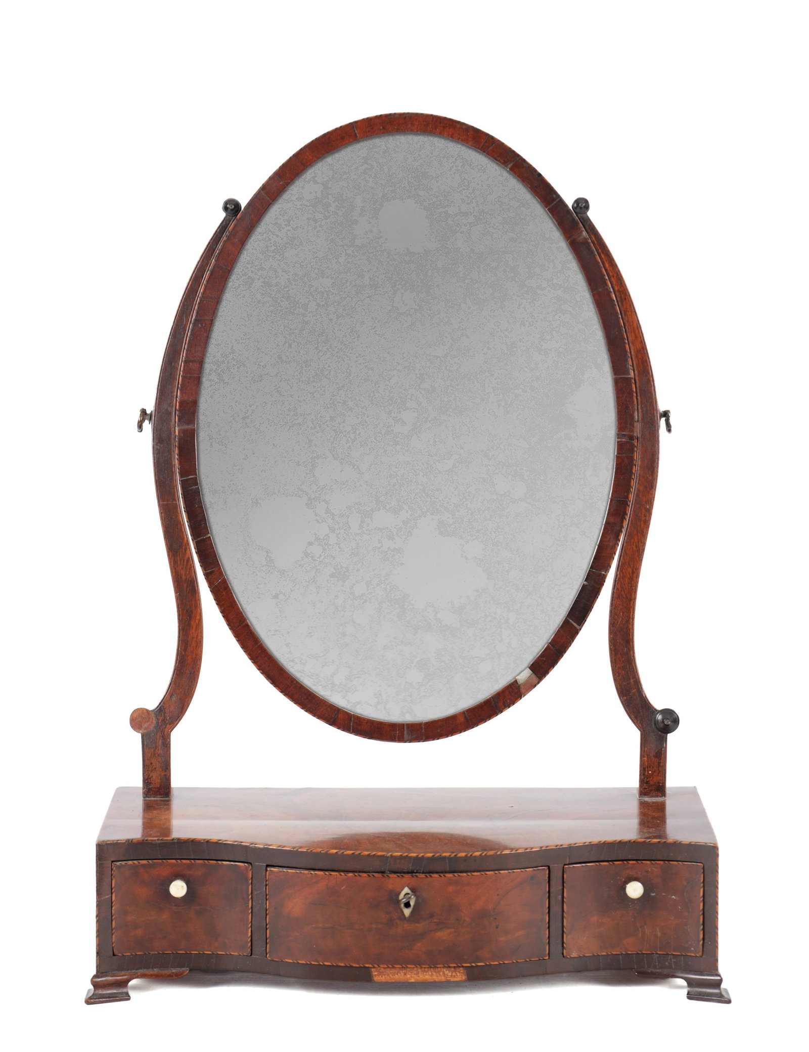A GEORGE III MAHOGANY SERPENTINE FRONTED TOILET MIRROR: A GEORGE III MAHOGANY SERPENTINE FRONTED TOILET MIRROR with an oval swing plate between shaped supports, the serpentine base fitted with three drawers and raised on bracket feet. (44cm wide 22cm deep