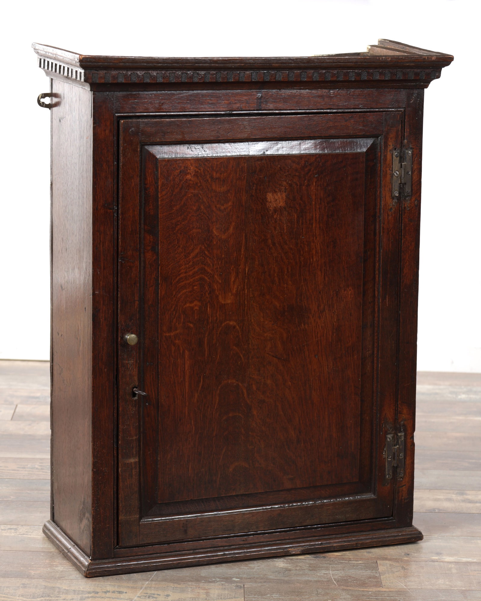AN EARLY 18TH CENTURY OAK HANGING CUPBOARD: AN EARLY 18TH CENTURY OAK HANGING CUPBOARD with panelled hinged doors having a fitted interior of small drawers. (64cm wide, 26cm deep and 82cm high)