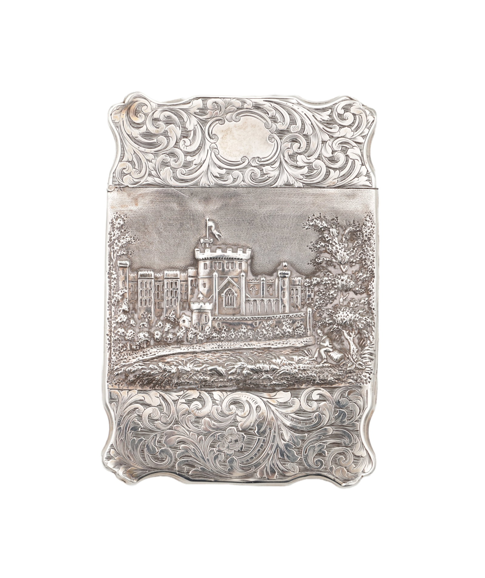 A VICTORIAN ENGLISH SILVER CARD CASE WITH CASTLE VIEW: A VICTORIAN ENGLISH SILVER CARD CASE WITH CASTLE VIEW chased with a view of a castellated mansion within scrollwork borders and of shaped outline, Birmingham 1841, 63g. (9.5cm high)