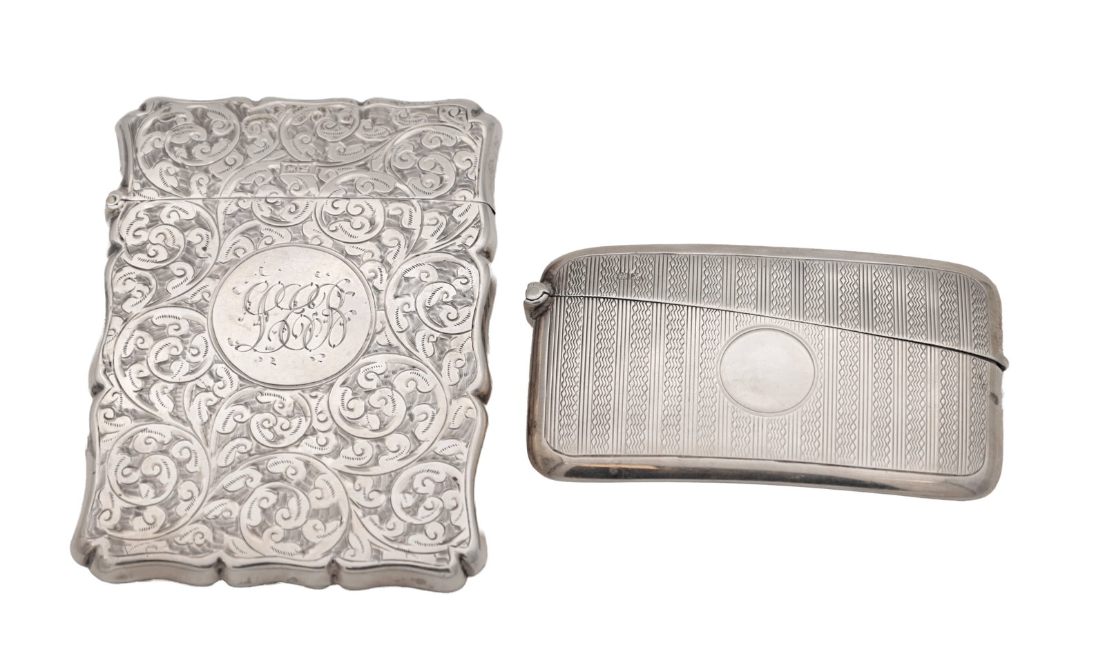 TWO EDWARDIAN ENGLISH SILVER CARD CASES: TWO EDWARDIAN ENGLISH SILVER CARD CASES both hallmarked Chester 1908, one of rectangular outline with all-over foliate scroll engraving and circular cartouche, the other of rounded oblong form with