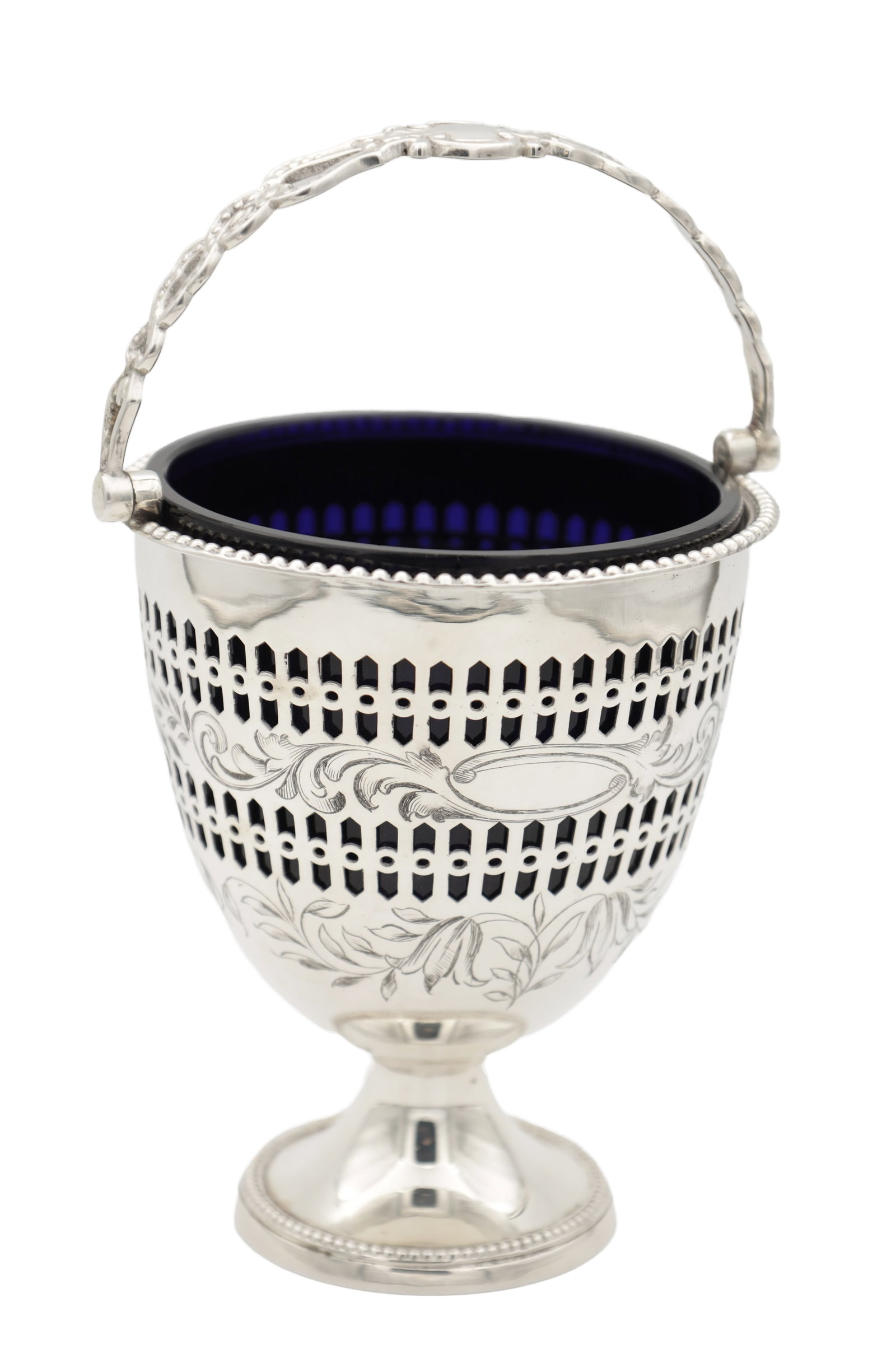 A 19TH/20TH CENTURY SILVER SUGAR BASKET WITH BLUE GLASS LINER: A 19TH/20TH CENTURY SILVER SUGAR BASKET WITH BLUE GLASS LINER of urn-shaped form with beaded rims and a swing handle, the body with pierced panels and engraved foliate scrolls with vacant cartouche,