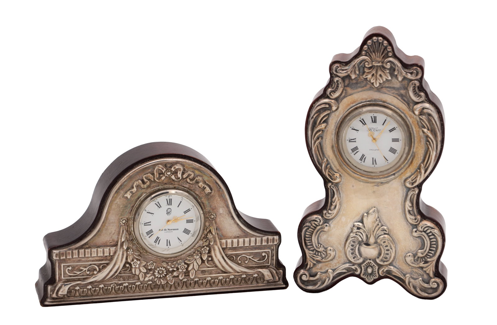 TWO ENGLISH SILVER MOUNTED MINIATURE MANTEL CLOCKS: TWO ENGLISH SILVER MOUNTED MINIATURE MANTEL CLOCKS one dial signed R. Carr England and the other Ari D. Norman London, each with Roman numeral dial and scroll decorated mounts on shaped wooden cases.