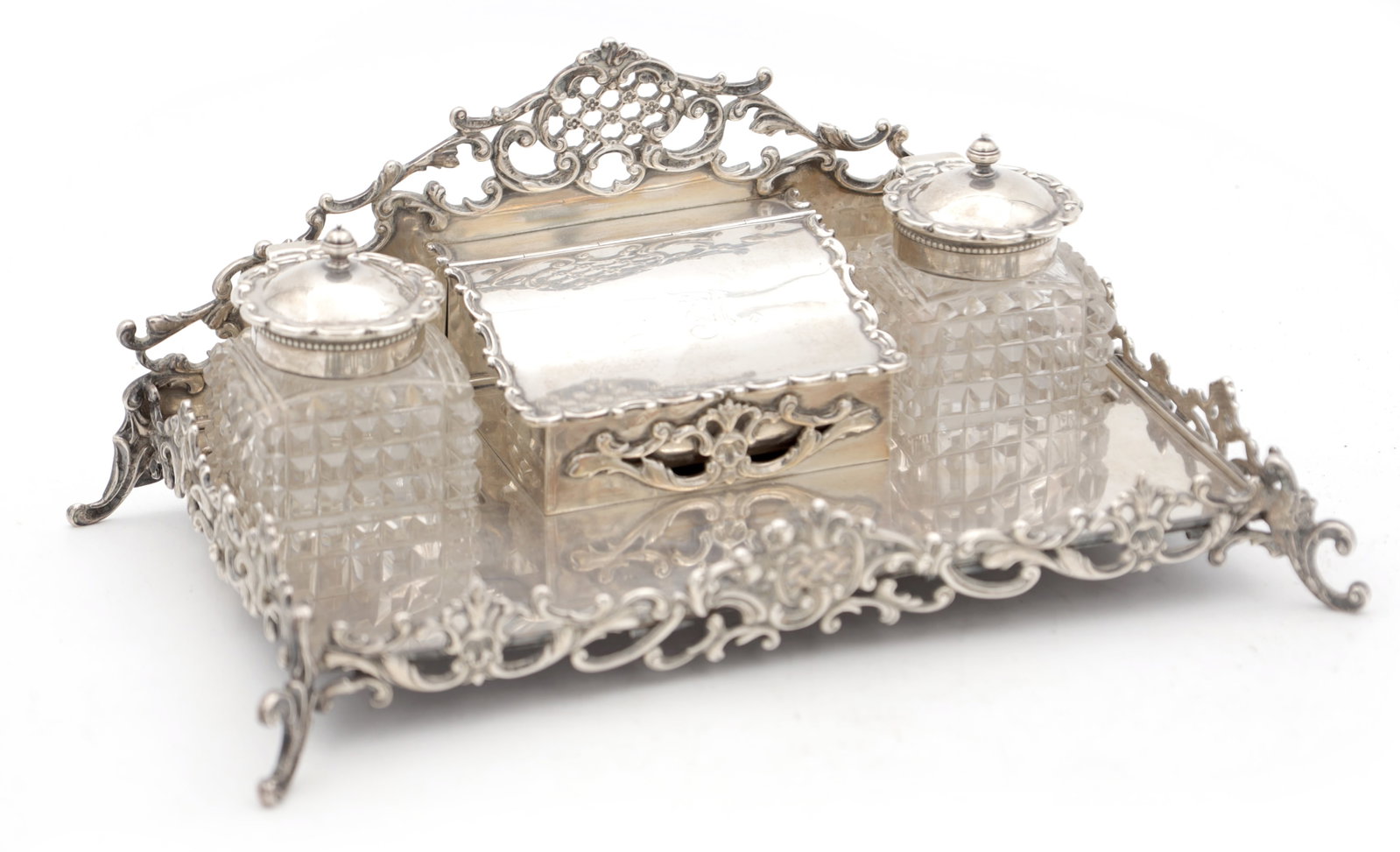AN AMERICAN SILVER INK STAND WITH CUT GLASS INKWELLS: AN AMERICAN SILVER INK STAND WITH CUT GLASS INKWELLS of rectangular tray form with a pierced scroll gallery and raised back, twin square hobnail-cut glass inkwells with silver covers flanking a