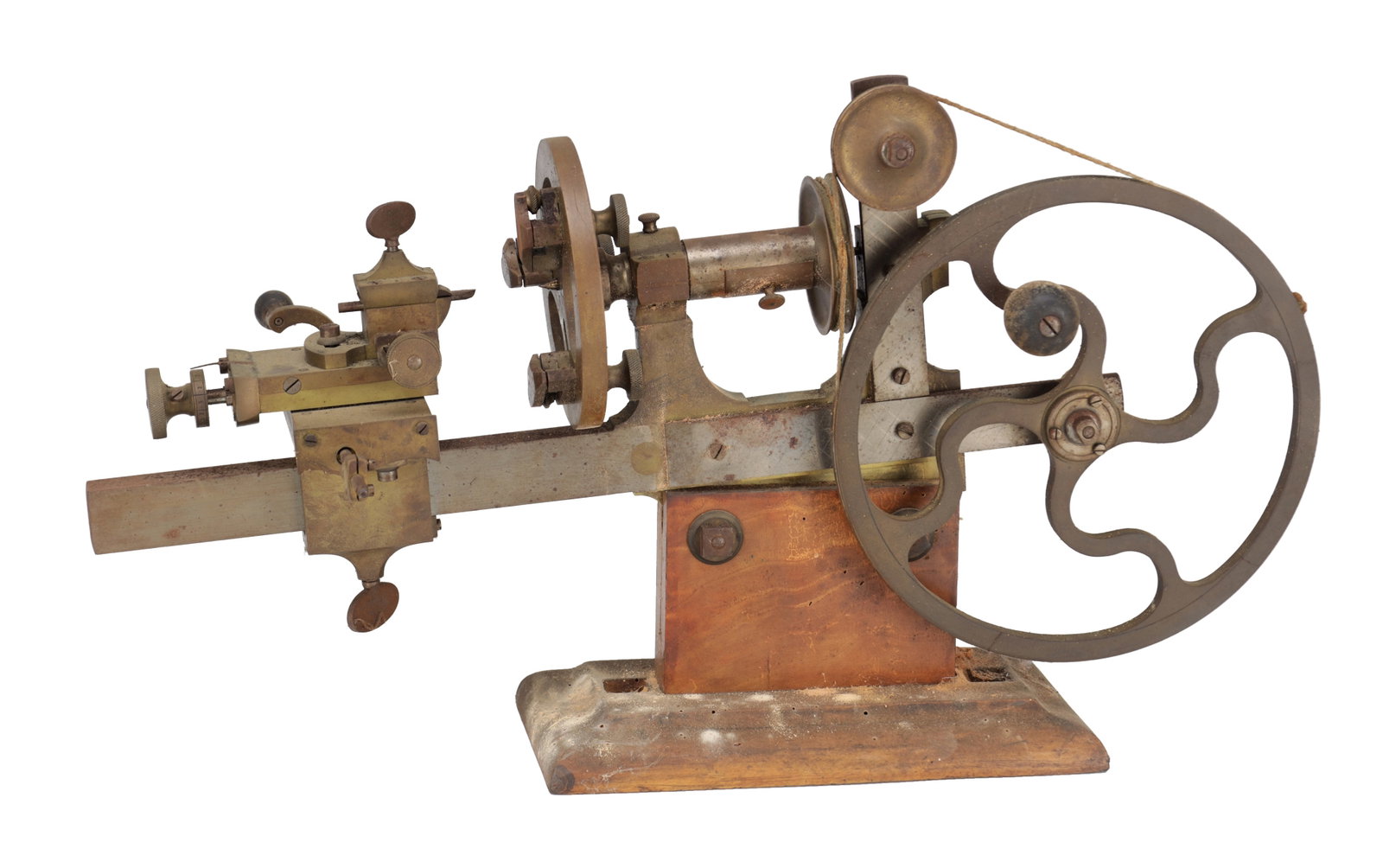 A BRASS AND STEEL WATCHMAKER'S LATHE: A BRASS AND STEEL WATCHMAKER'S LATHE of small bench form with large spoked flywheel driving headstock pulleys, with slide-rest on a steel bed, mounted on a wooden base. (52.5cm wide)
