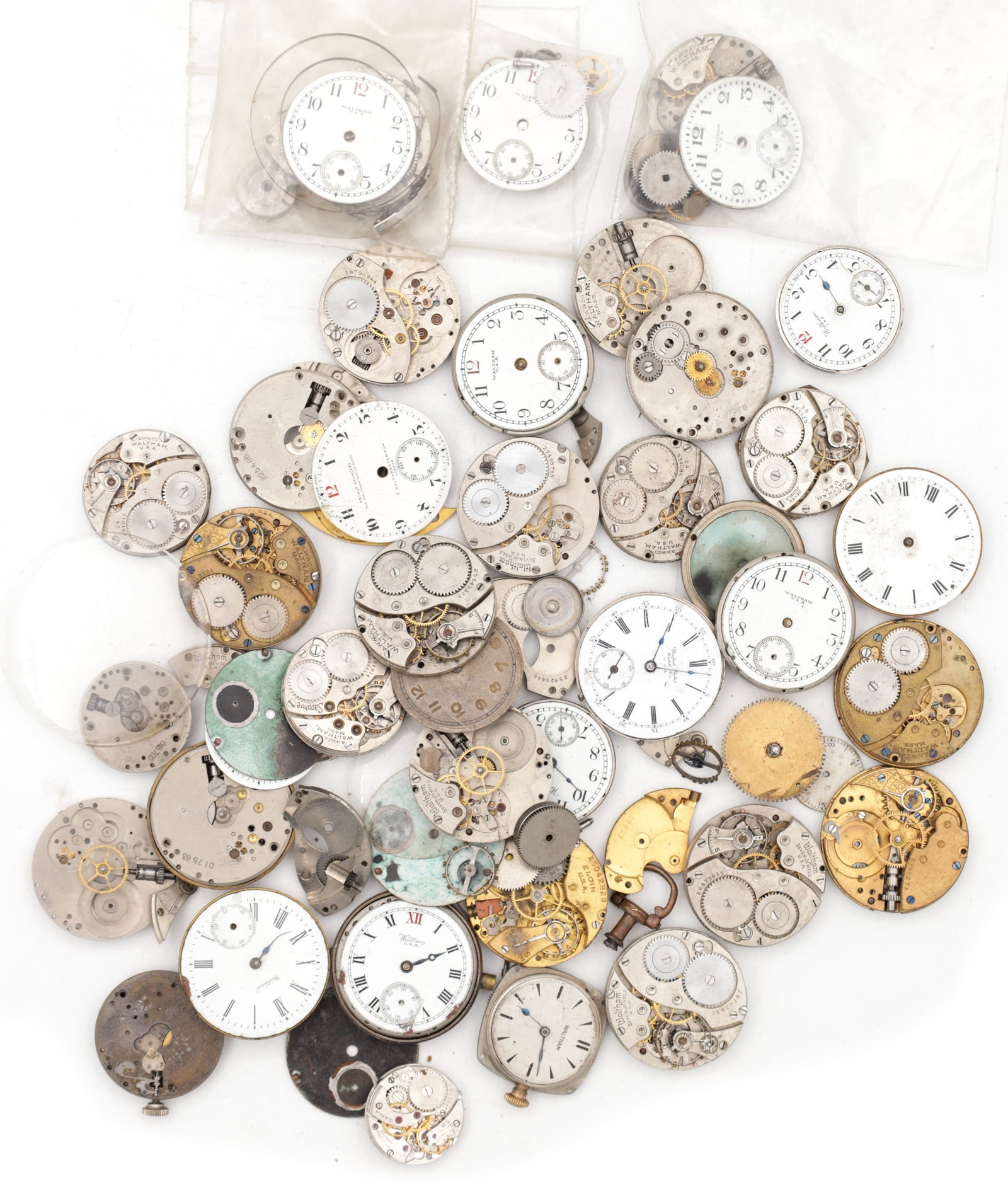 A COLLECTION OF AMERICAN WATCH MOVEMENTS AND PARTS: A COLLECTION OF AMERICAN WATCH MOVEMENTS AND PARTS comprising assorted pocket watch and wristwatch movements, many with enamel dials and subsidiary seconds, together with loose plates, bridges, gears 