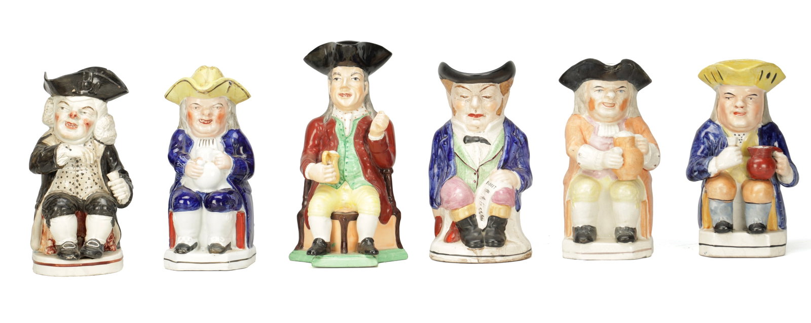 A COLLECTION OF 18TH AND 19TH CENTURY ENGLISH POTTERY TOBY JUGS: A COLLECTION OF 18TH AND 19TH CENTURY ENGLISH POTTERY TOBY JUGS comprising six seated figures in tricorn hats variously holding mugs, jugs and pipes with polychrome glazes. (Up to 28cm high)
