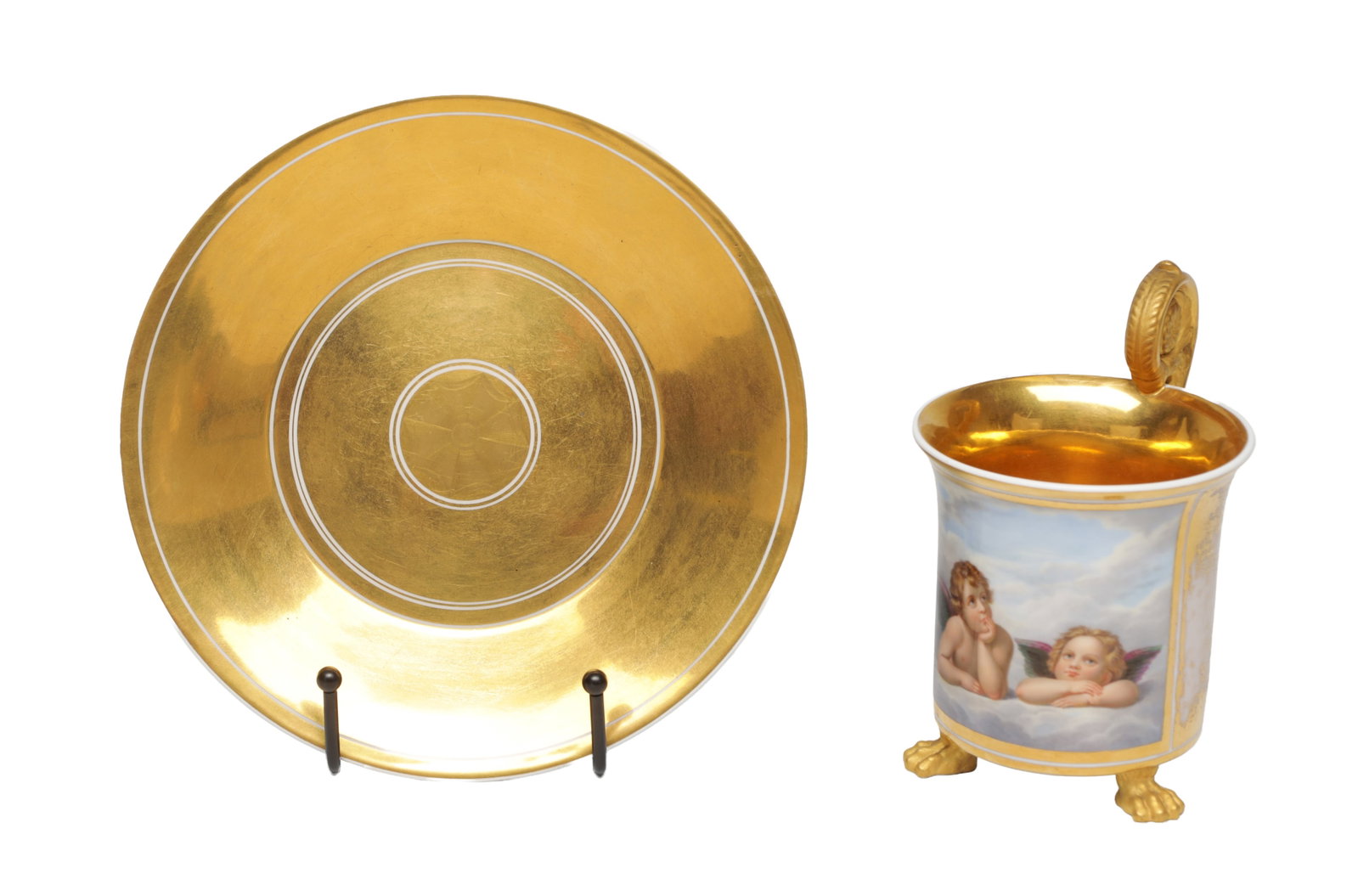 A 19TH CENTURY KPM BERLIN PORCELAIN CUP AND SAUCER: A 19TH CENTURY KPM BERLIN PORCELAIN CUP AND SAUCER with a beaker-shaped cup painted with a rectangular reserve of two winged putti on clouds within tooled gilt borders, the interior richly gilt, with 