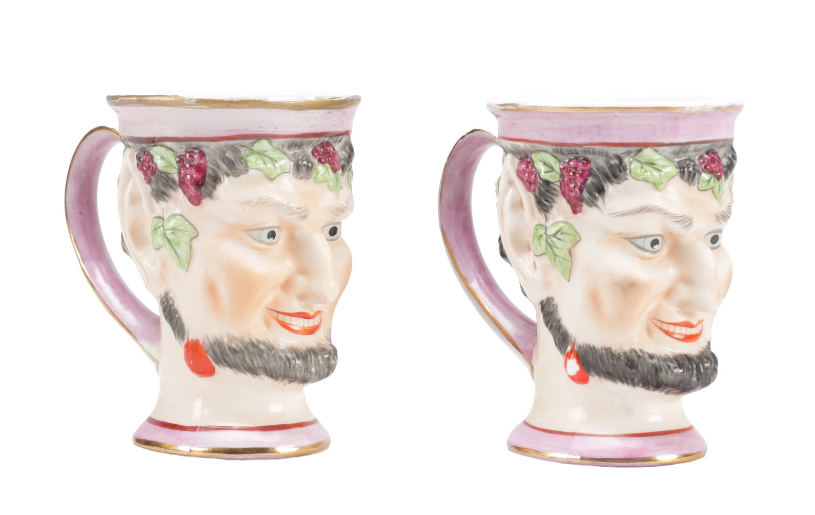 TWO EARLY 19TH CENTURY ENGLISH POTTERY BACCHUS HEAD JUGS: TWO EARLY 19TH CENTURY ENGLISH POTTERY BACCHUS HEAD JUGS modelled as the bearded god with grape and vine wreaths, polychrome painted with pink lustre and gilt highlights, each with an everted rim and 