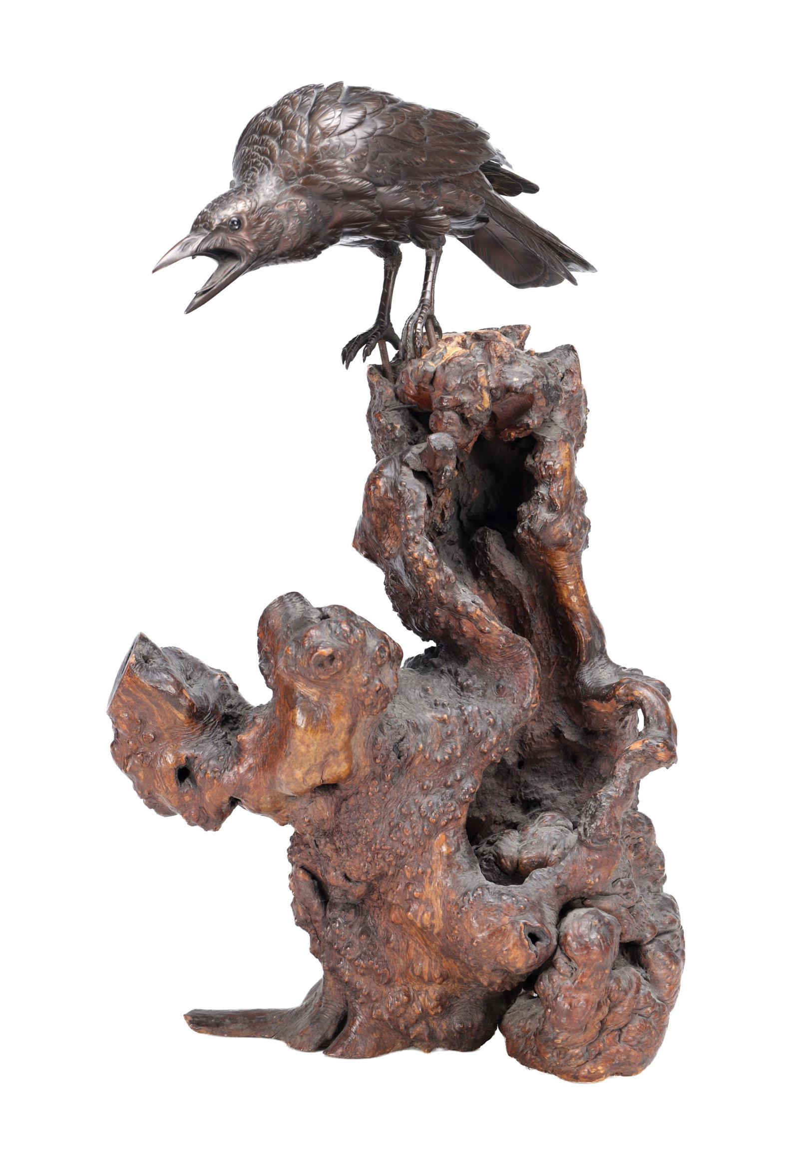 A MEIJI PERIOD JAPANESE BRONZE CROW ON ROOTWOOD BASE: A MEIJI PERIOD JAPANESE BRONZE CROW ON ROOTWOOD BASE the patinated bronze naturalistically modelled with open beak and finely detailed plumage, perched upon a gnarled rootwood stand, signed beneath. (