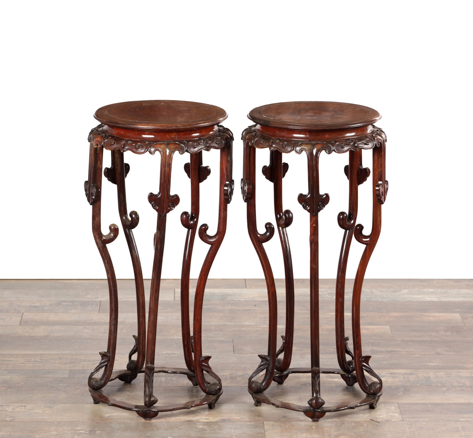 A PAIR OF 19TH CENTURY CHINESE HARDWOOD JARDINIERE STANDS: A PAIR OF 19TH CENTURY CHINESE HARDWOOD JARDINIERE STANDS with burr tops above a carved and pierced apron, each raised on six slender cabriole supports with ruyi-head brackets united by a shaped