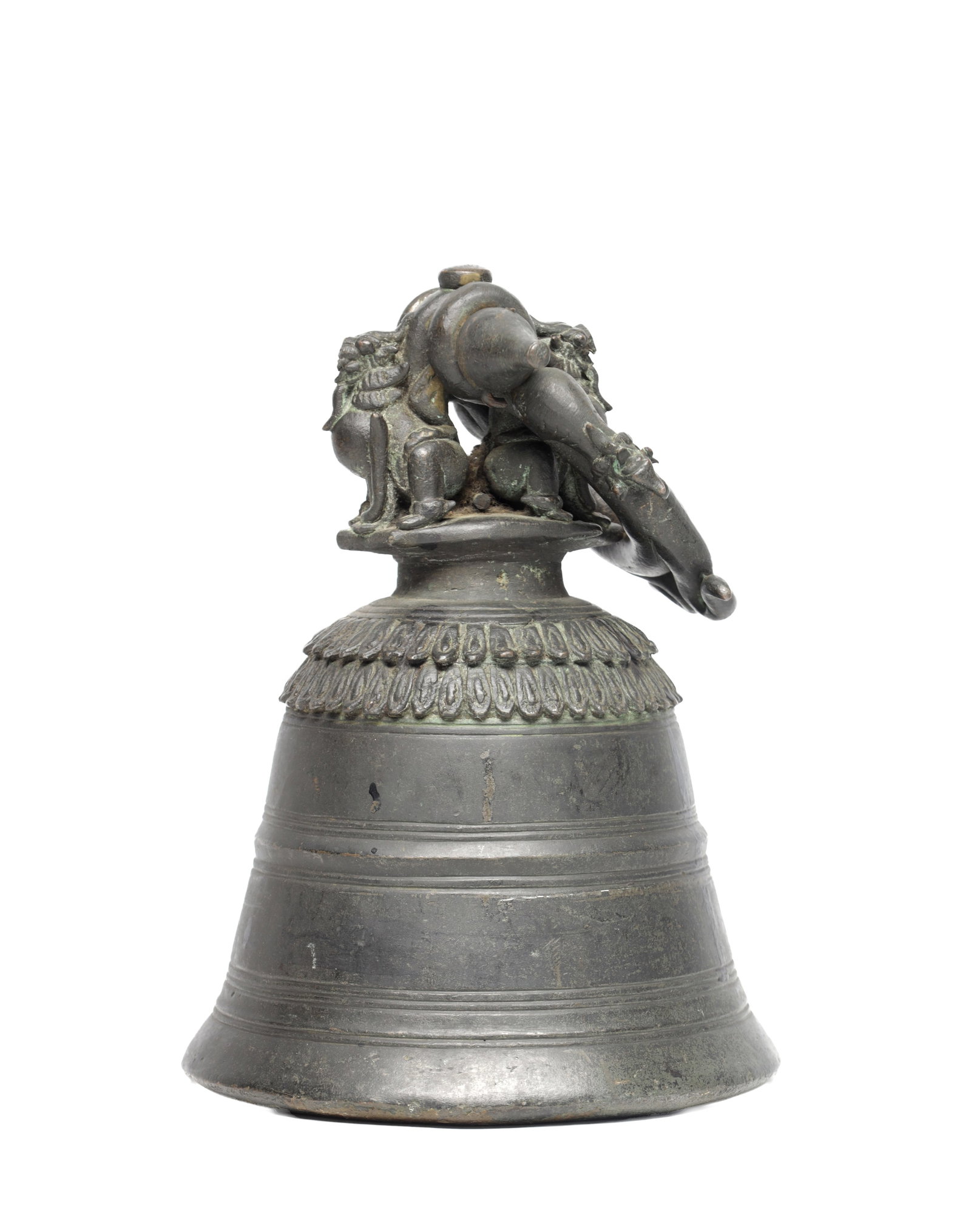 A CHINESE BRONZE BELL WITH ELEPHANT FINIAL: A CHINESE BRONZE BELL WITH ELEPHANT FINIAL of flared form with incised concentric bands and splayed lip, a lotus-lappet collar below the crown surmounted by a capstan handle cast as an elephant with f
