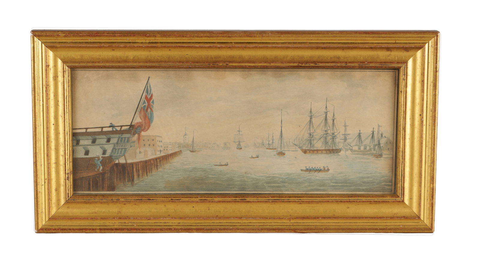 AN 18TH/19TH CENTURY MARITIME WATERCOLOUR: AN 18TH/19TH CENTURY MARITIME WATERCOLOUR depicting a harbour scene with British warships and smaller craft, a large ensign at the stern of a moored vessel by the quay to the left with figures on the