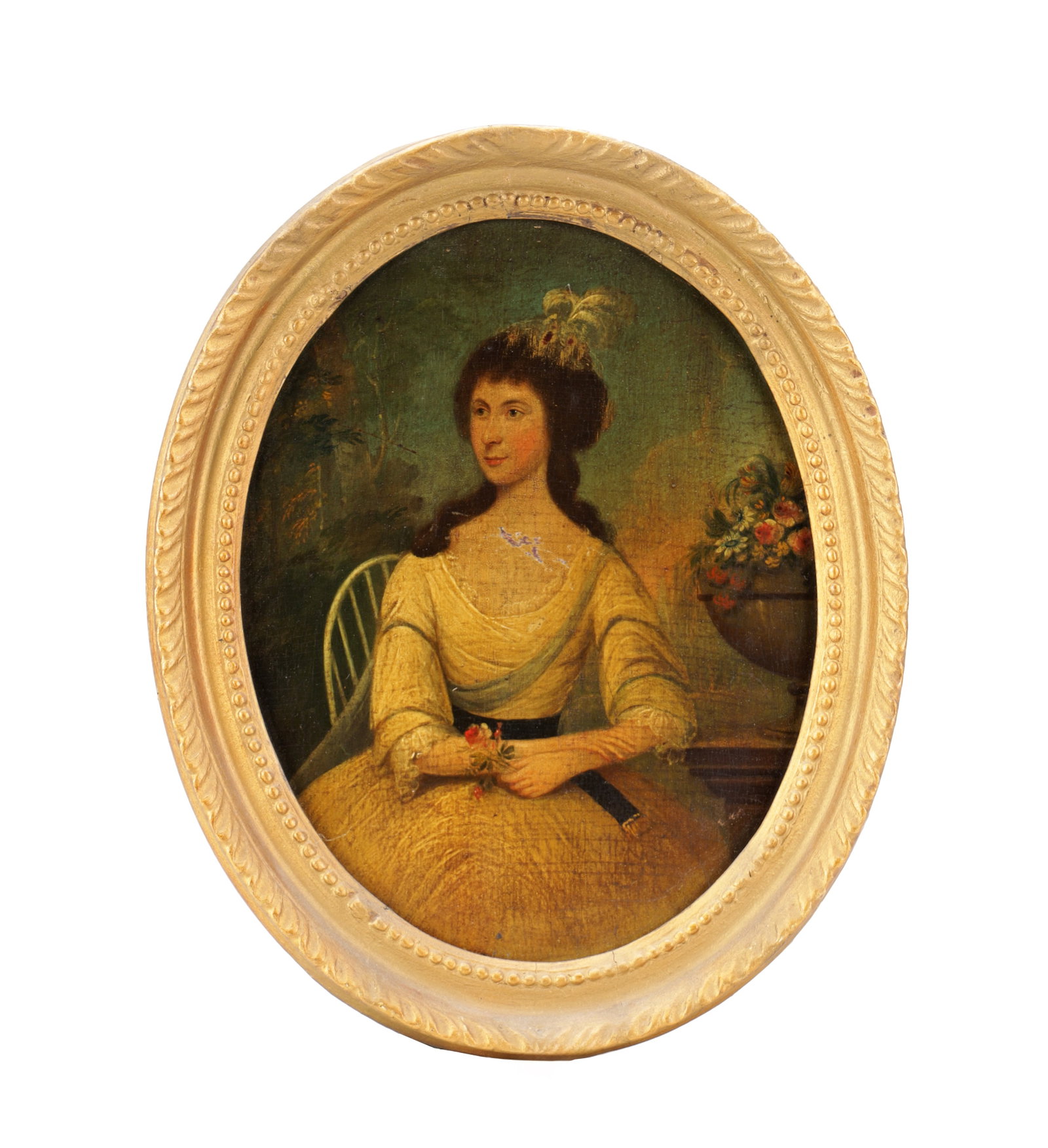 A LATE 18TH CENTURY OIL ON CANVAS PORTRAIT OF A LADY IN GILT OVAL FRAME: A LATE 18TH CENTURY OIL ON CANVAS PORTRAIT OF A LADY IN GILT OVAL FRAME depicting a seated lady in a yellow dress holding flowers with a feathered headdress before a verdant ground with an urn of