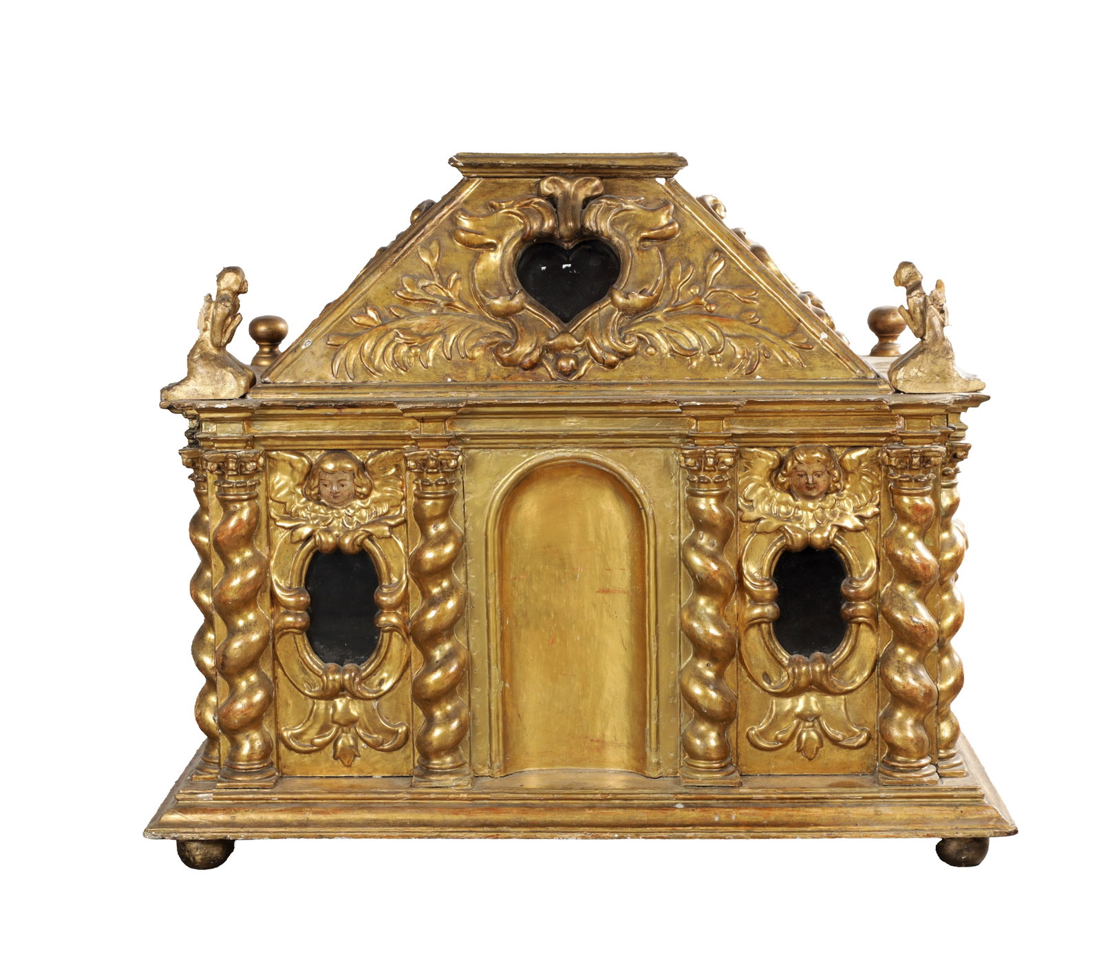 A 19TH CENTURY BAROQUE STYLE CARVED WOOD AND PARCEL GILT RELIQUARY SHRINE: A 19TH CENTURY BAROQUE STYLE CARVED WOOD AND PARCEL GILT RELIQUARY SHRINE with an architectural facade centred by an arched door flanked by twisted columns and oval reliquary apertures beneath cherub