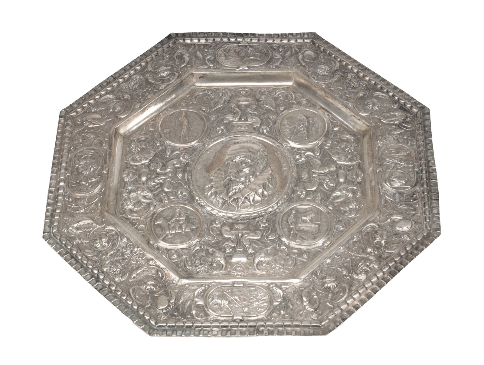 A SILVER PLATED CHARGER WITH RELIEF PORTRAIT OF MIGUEL DE CERVANTES: A SILVER PLATED CHARGER WITH RELIEF PORTRAIT OF MIGUEL DE CERVANTES of octagonal form with a central bust medallion, the field with repousse and chased foliate scrollwork and figural roundels, finishe