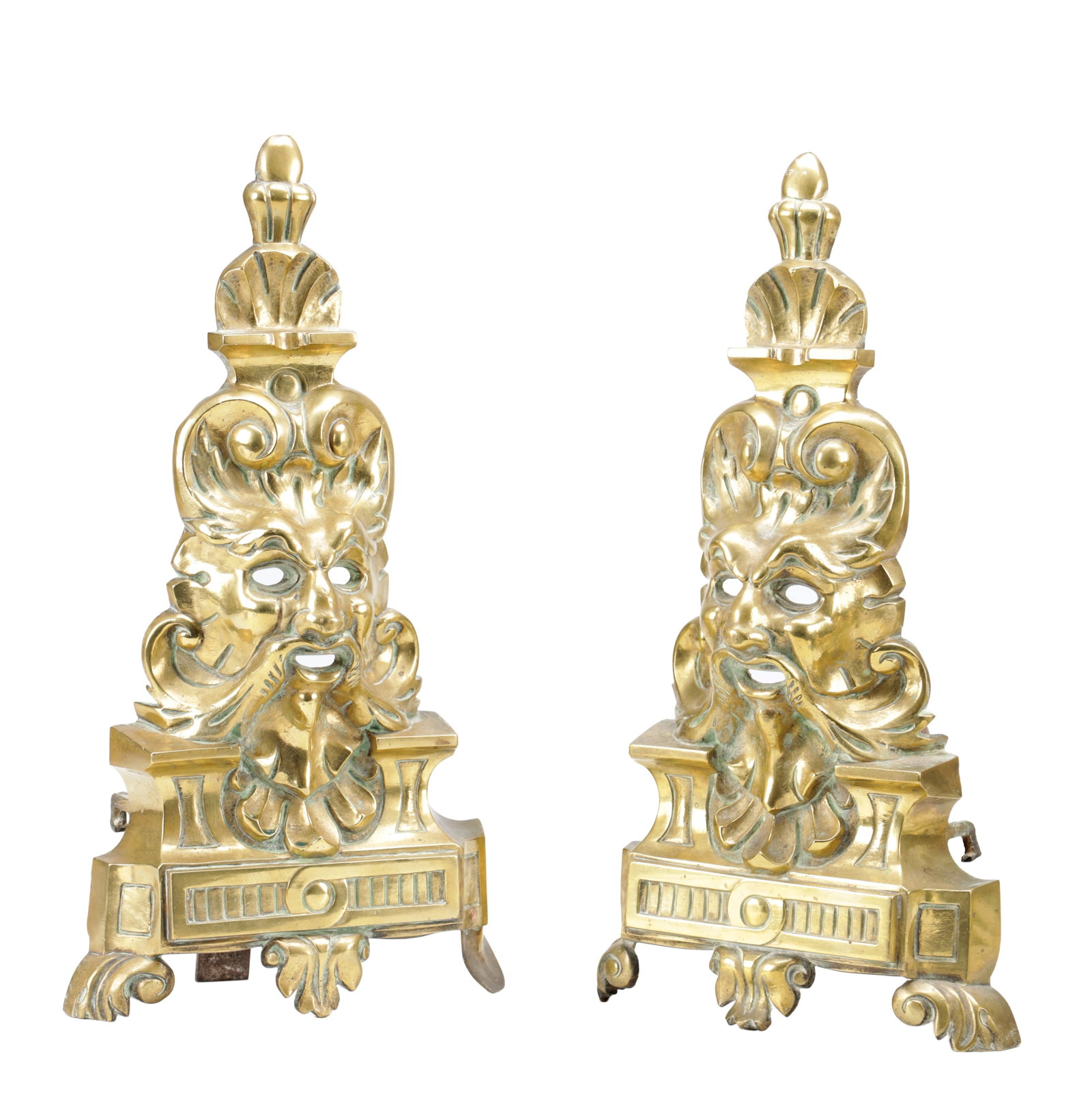 A PAIR OF LATE 19TH CENTURY GILT AND POLISHED BRASS FIRE DOGS: A PAIR OF LATE 19TH CENTURY GILT AND POLISHED BRASS FIRE DOGS of upright form with urn finials, each cast with a Green Man mask amid scrolls above a panelled plinth, raised on scrolled feet. (39cm by