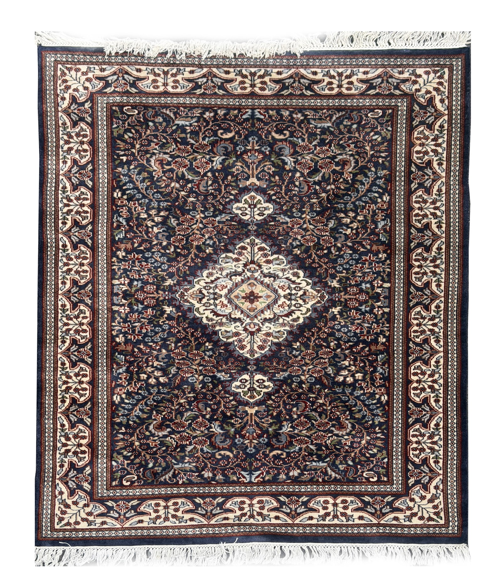 A PERSIAN TABRIZ MAHI CARPET: A PERSIAN TABRIZ MAHI CARPET with an ivory central medallion on a deep blue field densely worked with the mahi herati pattern, within cream palmette and vine borders and fringed ends. (180cm by 122cm)