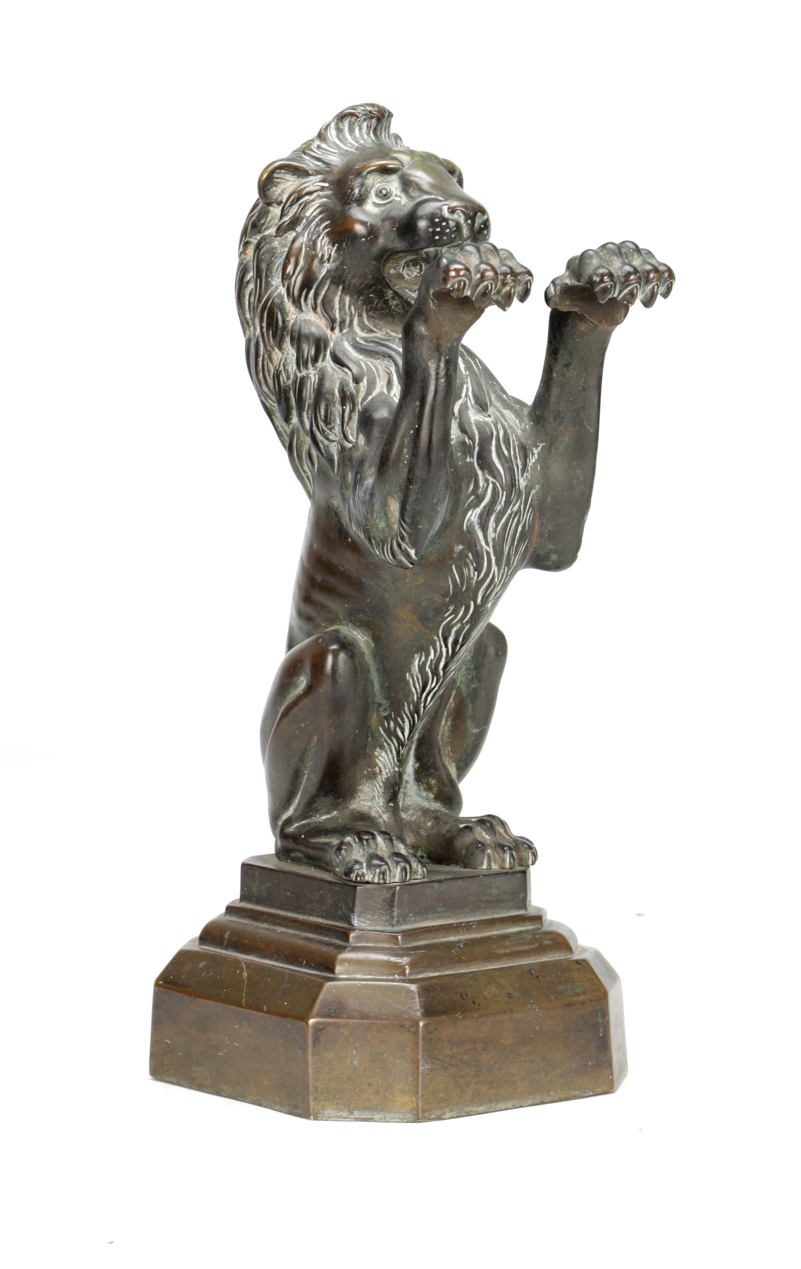 A 19TH CENTURY BRONZE LION DOORSTOP ON STEPPED PLINTH BASE: A 19TH CENTURY BRONZE LION DOORSTOP ON STEPPED PLINTH BASE modelled seated upright with raised forepaws and flowing mane in a patinated bronze, the canted base with moulded steps. (36cm high)
