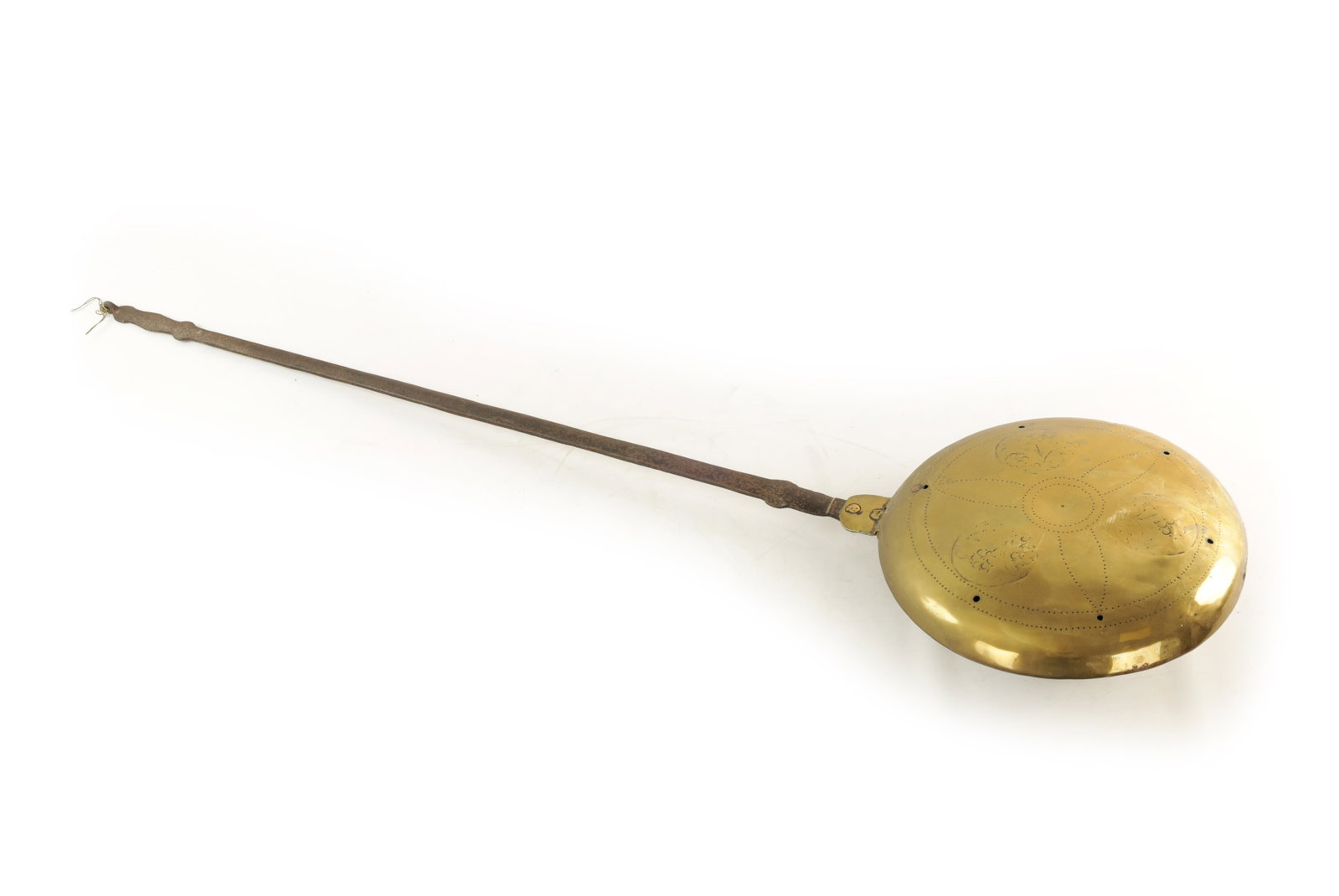 A 17TH CENTURY BRASS AND IRON WARMING PAN: A 17TH CENTURY BRASS AND IRON WARMING PAN with a long shaped wrought iron handle and a domed hinged pierced cover engraved with flowerhead motifs. (121cm overall )