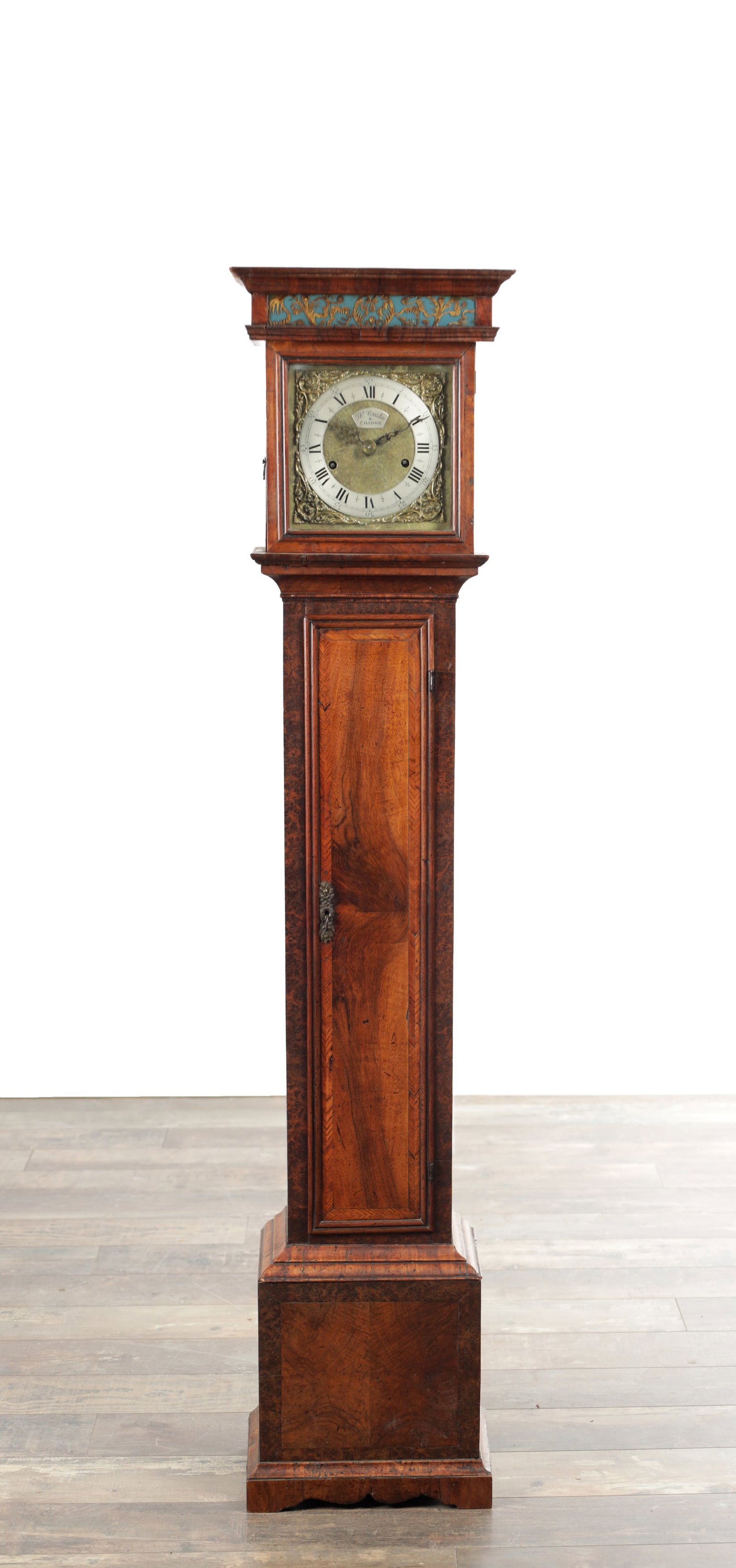A 19TH CENTURY FIGURED WALNUT MINIATURE LONGCASE CLOCK: A 19TH CENTURY FIGURED WALNUT MINIATURE LONGCASE CLOCK the hood with moulded pediment above an eglomise frieze and moulded door, the trunk with moulded edge door and herringbone crossbanding, the 7in 