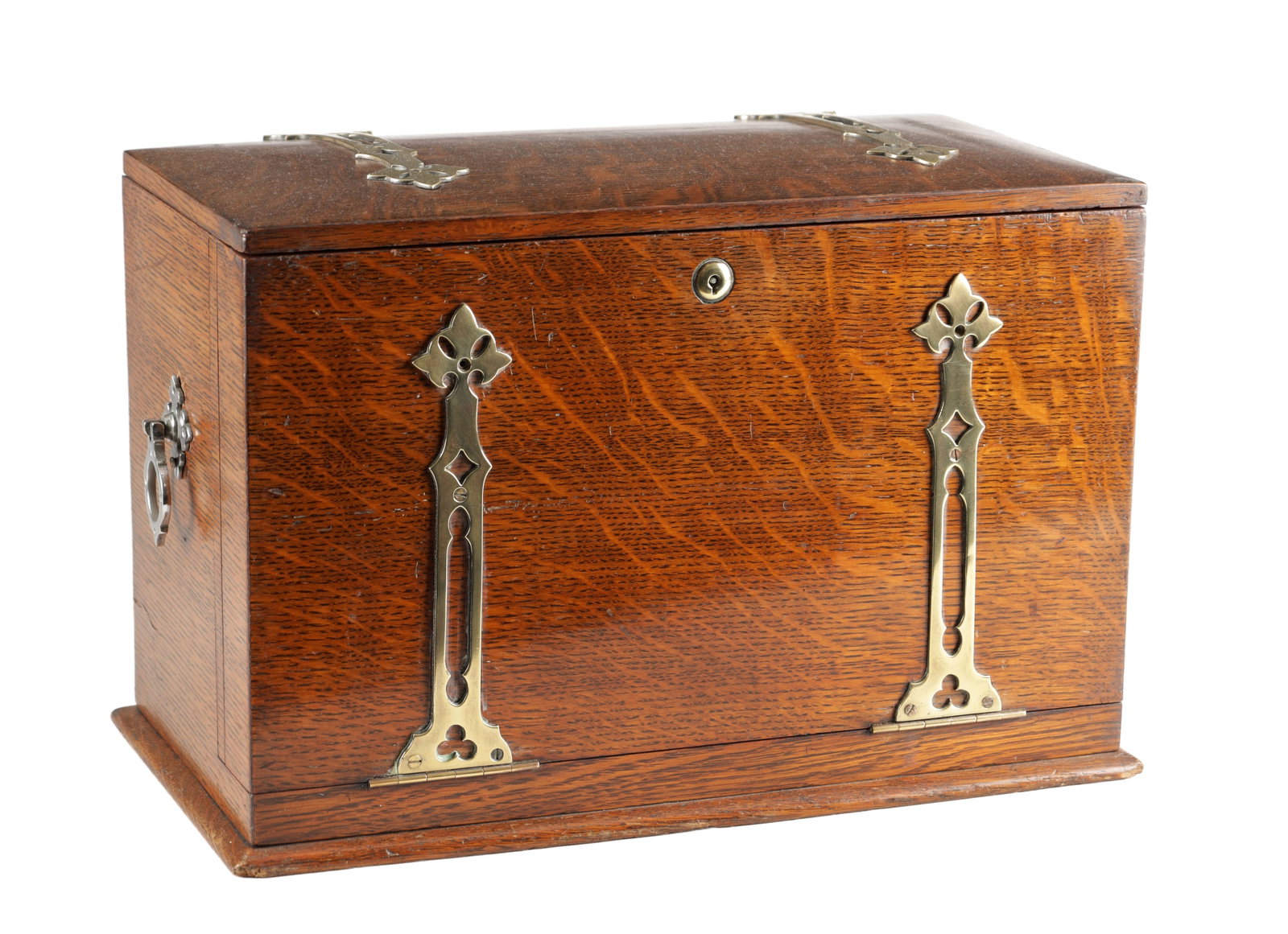 AN ARTS AND CRAFTS OAK WRITING BOX WITH PIERCED BRASS MOUNTS: AN ARTS AND CRAFTS OAK WRITING BOX WITH PIERCED BRASS MOUNTS of rectangular form with hinged cover, the front applied with Gothic strapwork mounts with quatrefoil piercings and central key escutcheon,