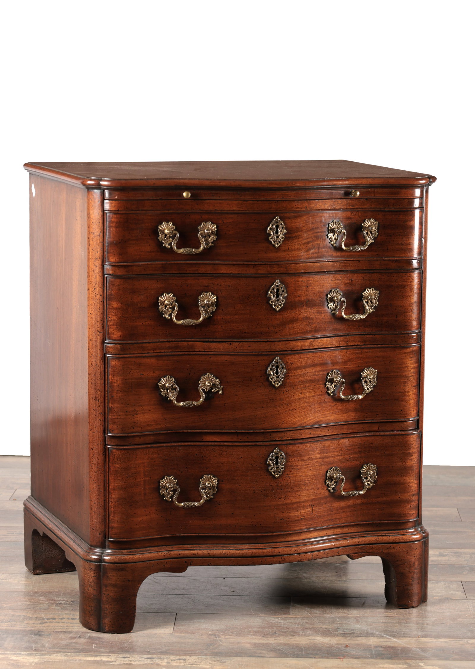 AN UNUSUAL GEORGE III MAHOGANY SERPENTINE CHEST OF DRAWERS WITH BRUSHING SLIDE: AN UNUSUAL GEORGE III MAHOGANY SERPENTINE CHEST OF DRAWERS WITH BRUSHING SLIDE the moulded top above a pull-out brushing slide and four long graduated serpentine-front drawers with cockbeaded edges, b