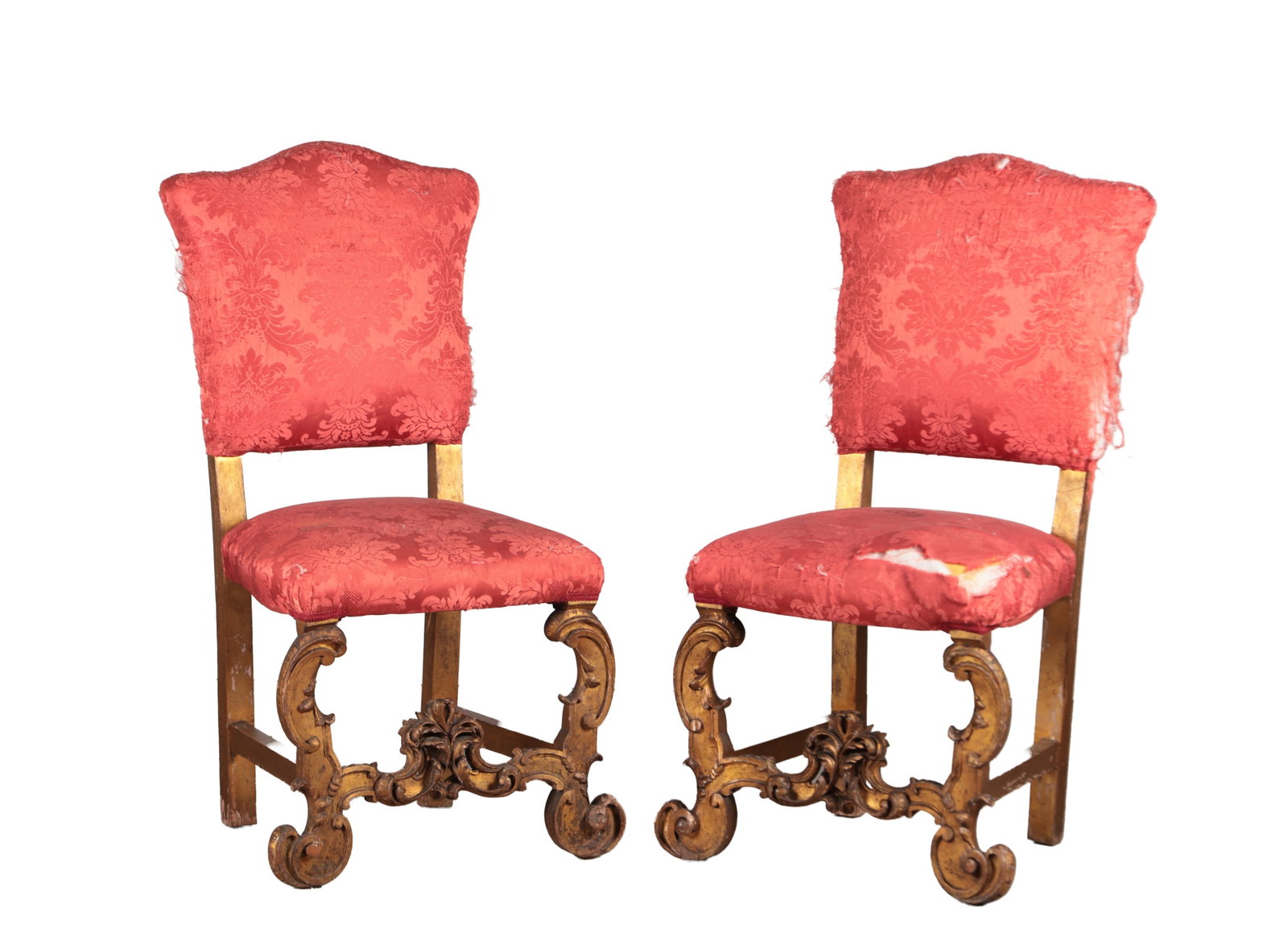 A PAIR OF CARVED GILT WOOD SIDE CHAIRS: A PAIR OF CARVED GILT WOOD SIDE CHAIRS each with a shaped upholstered back and seat in crimson damask raised on scrolled front legs united by a foliate-carved stretcher with central cartouche, the