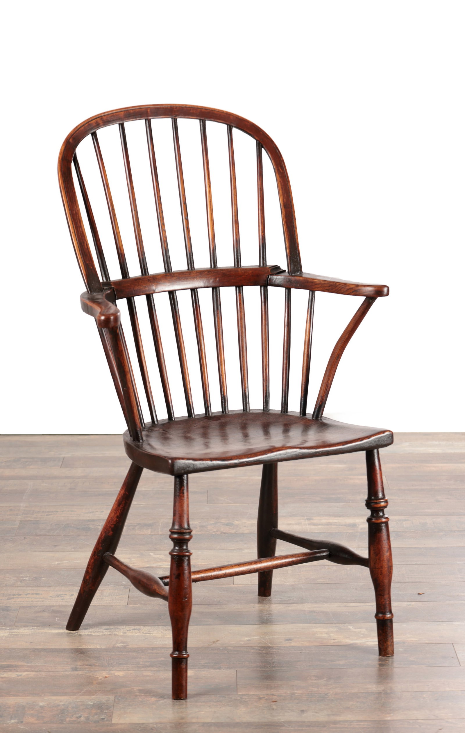 A LATE 18TH CENTURY WEST COUNTRY ASH AND ELM STICK-BACK WINDSOR ARMCHAIR: A LATE 18TH CENTURY WEST COUNTRY ASH AND ELM STICK-BACK WINDSOR ARMCHAIR with hoop back and outswept arms on stick supports, the shaped single-piece seat raised on ring-turned legs joined by an H-stre