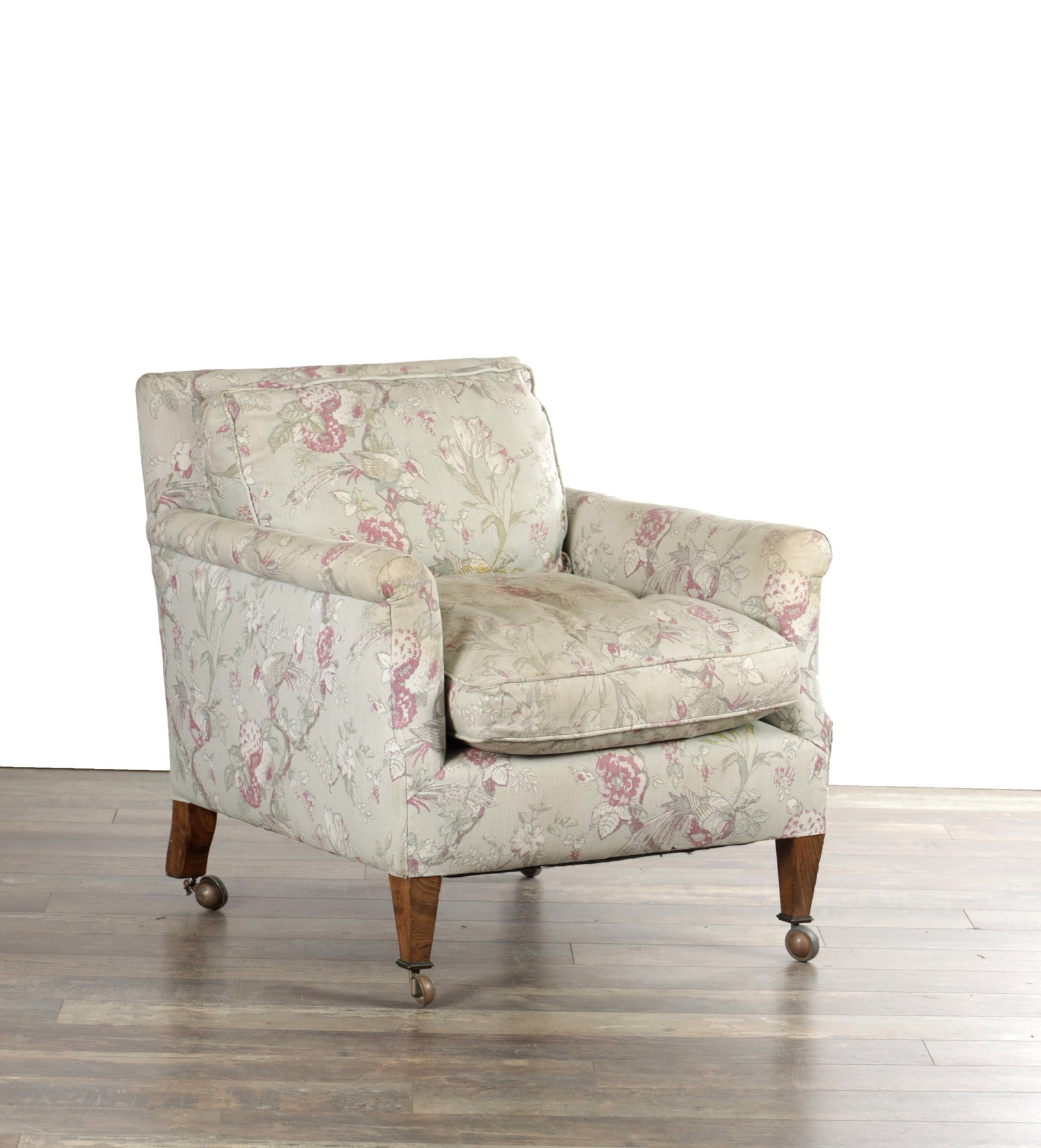 A 20TH CENTURY HOWARD & SONS LTD LONDON UPHOLSTERED ARMCHAIR NO.145: A 20TH CENTURY HOWARD & SONS LTD LONDON UPHOLSTERED ARMCHAIR NO.145 with floral covers, padded scroll arms and loose back and seat cushions, raised on square tapering legs with brass casters. (75cm hi