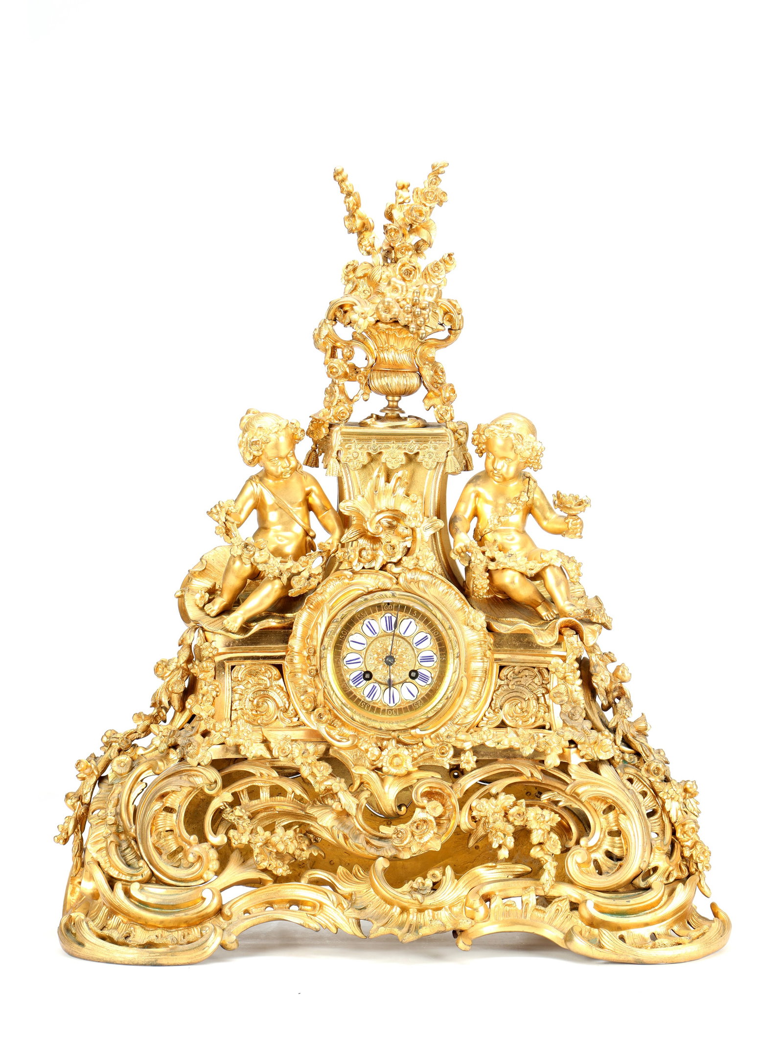 BARRARD & VIGNON, PARIS. A LARGE LATE 19TH CENTURY FRENCH ORMOLU FIGURAL MANTEL CLOCK: BARRARD & VIGNON, PARIS. A LARGE LATE 19TH CENTURY FRENCH ORMOLU FIGURAL MANTEL CLOCK having a finely cast scrolling foliate and floral case surmounted by an overflowing urn and flanked by seated putt