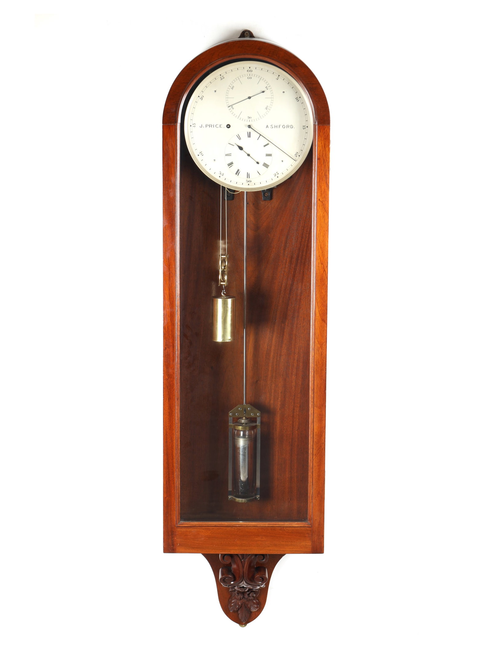 J. PRICE, ASHFORD. A LATE 19TH CENTURY MAHOGANY WALL REGULATOR: J. PRICE, ASHFORD. A LATE 19TH CENTURY MAHOGANY WALL REGULATOR with arched glazed trunk door and carved leaf-decorated base, enclosing a 12' silvered engraved dial with outer minutes surrounding subsi
