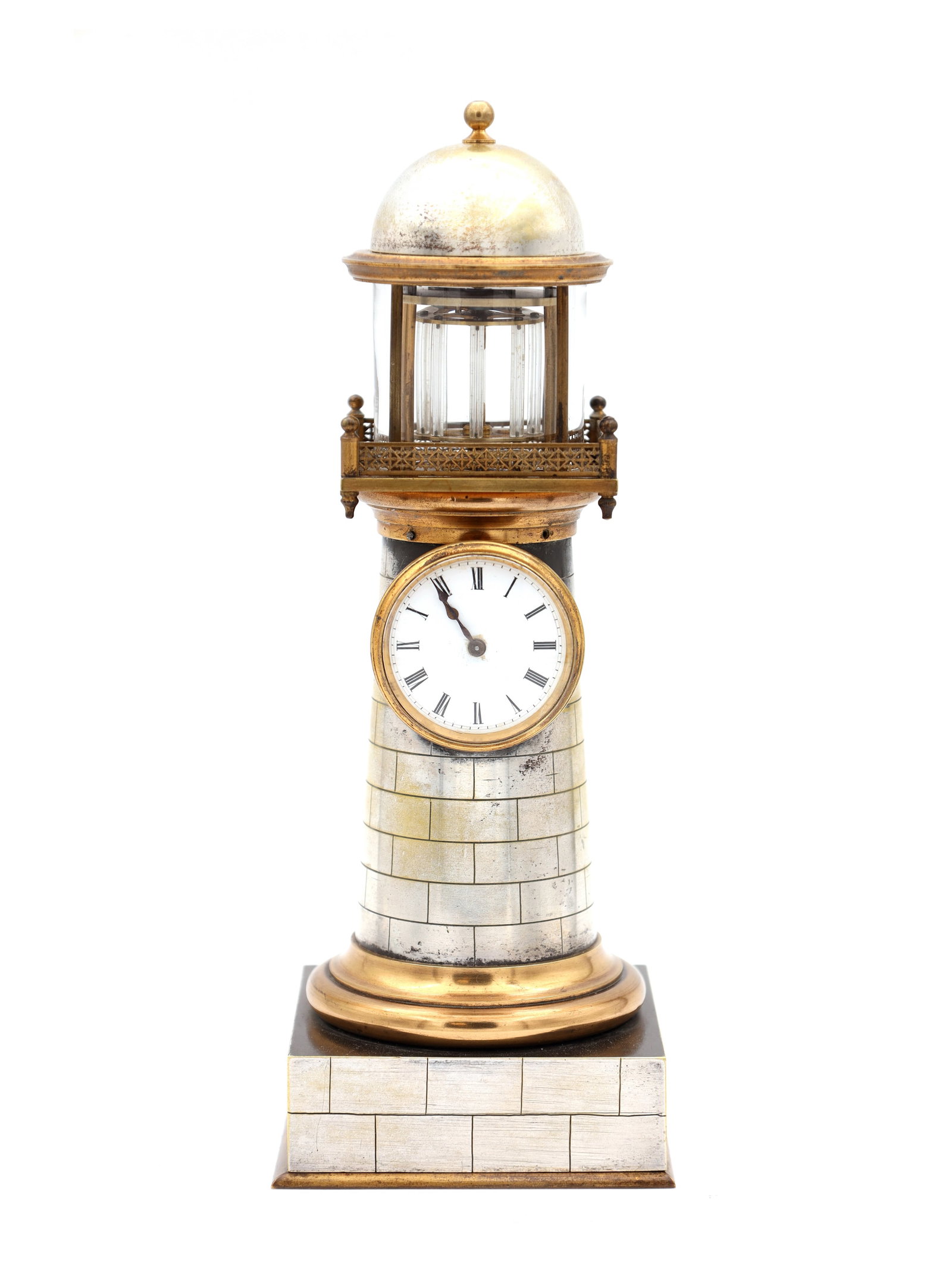 GUILMET, PARIS. A LATE 19TH CENTURY BRASS AND SILVERED BRASS AUTOMATION LIGHTHOUSE MANTEL CLOCK: GUILMET, PARIS. A LATE 19TH CENTURY BRASS AND SILVERED BRASS AUTOMATION LIGHTHOUSE MANTEL CLOCK of tapering cylindrical tower form with simulated ashlar stonework and moulded plinth on a square base, 