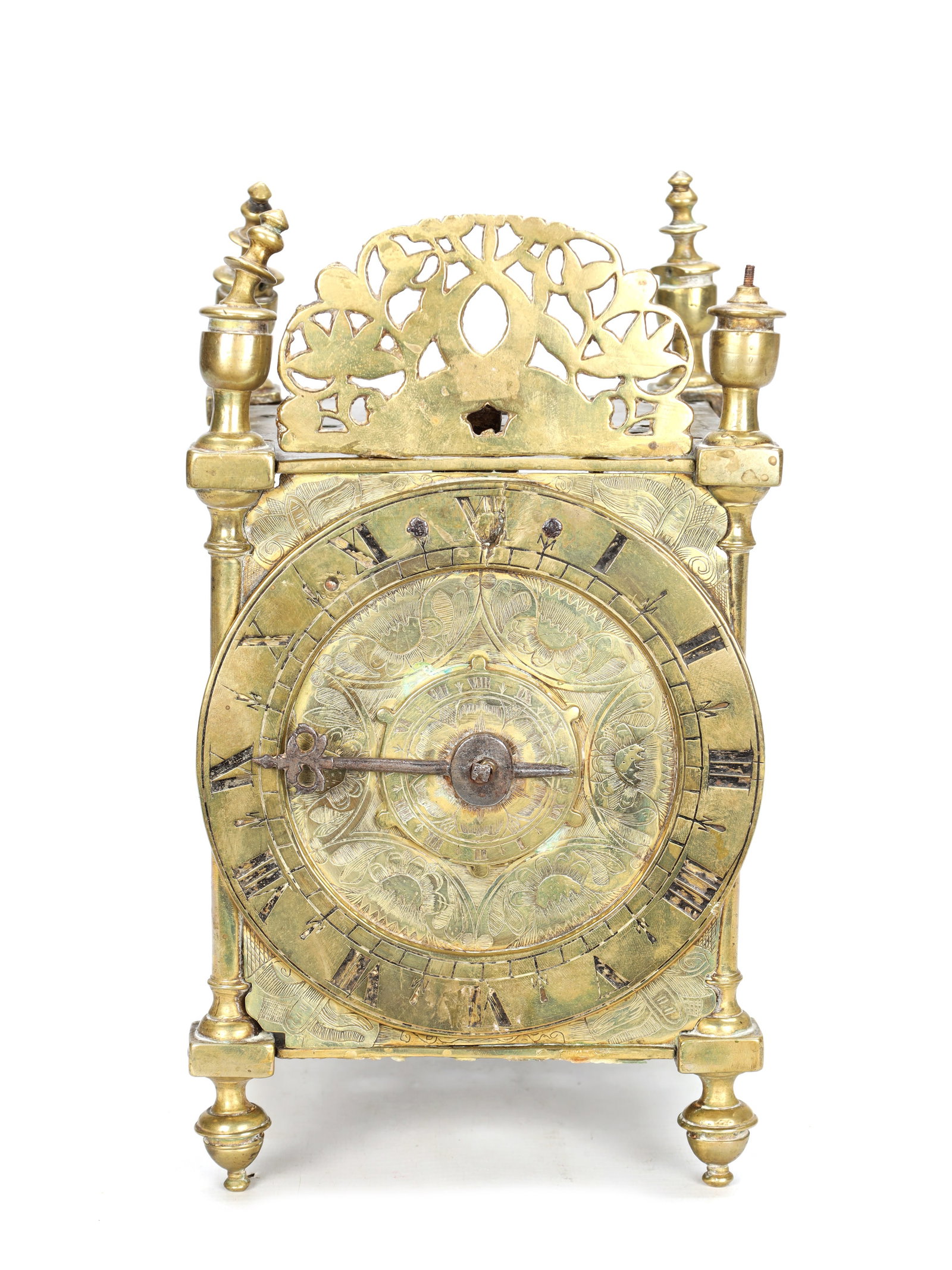 A FIRST PERIOD ENGLISH BRASS LANTERN CLOCK WITH TULIP ENGRAVED DIAL: A FIRST PERIOD ENGLISH BRASS LANTERN CLOCK WITH TULIP ENGRAVED DIAL the brass posted case with turned finials, pierced foliate front fret and turned bun feet enclosing a 6' narrow chapter ring with Ro
