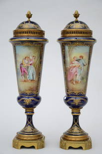 A pair of lidded vases in Sèvres porcelain painted: A pair of lidded vases in Sè